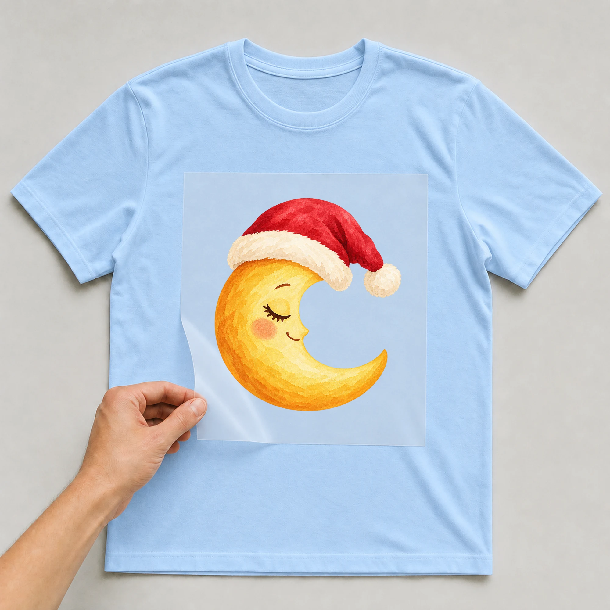 Bügelbild „Weihnachten Mond“ auf babyblauem T-Shirt, Folie wird aufgelegt