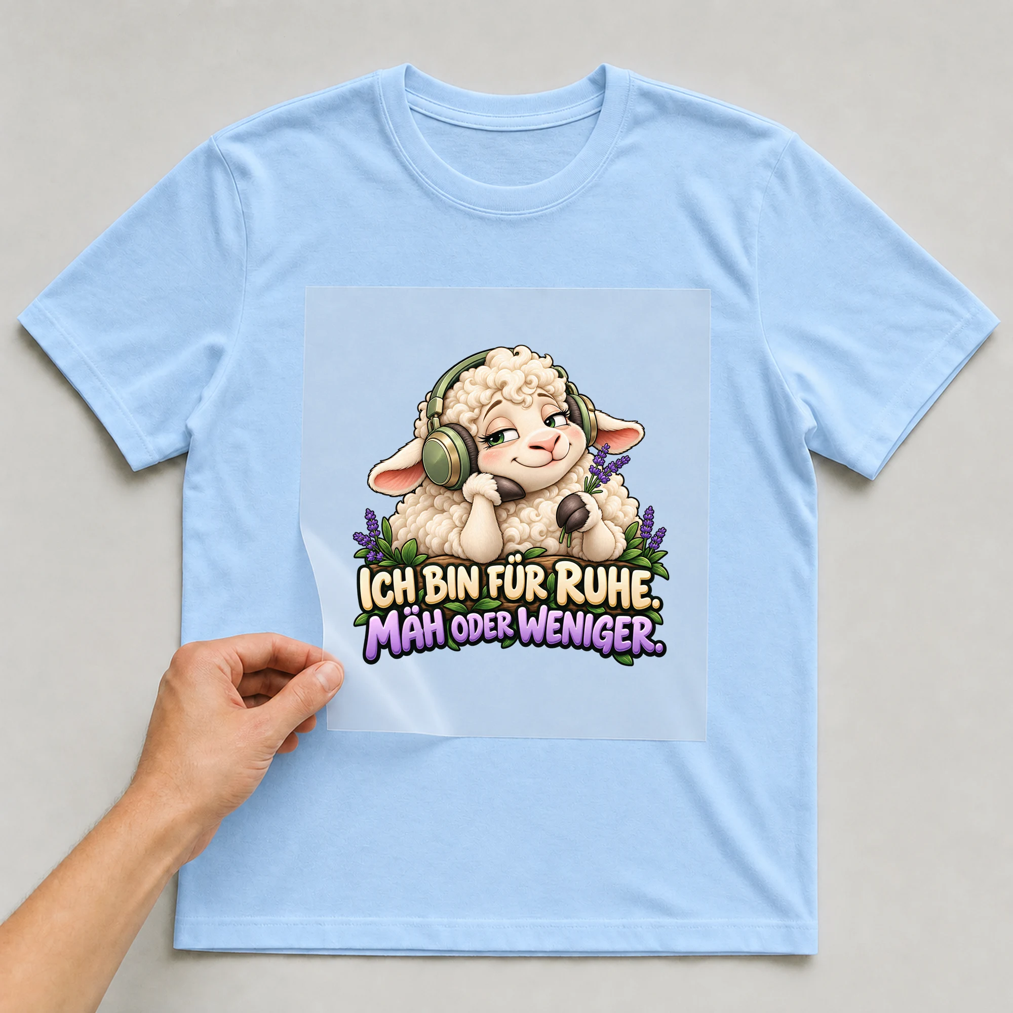 Bügelbild „Ich bin für Ruhe. Mäh oder weniger.“ auf babyblauem T-Shirt, Folie wird aufgelegt