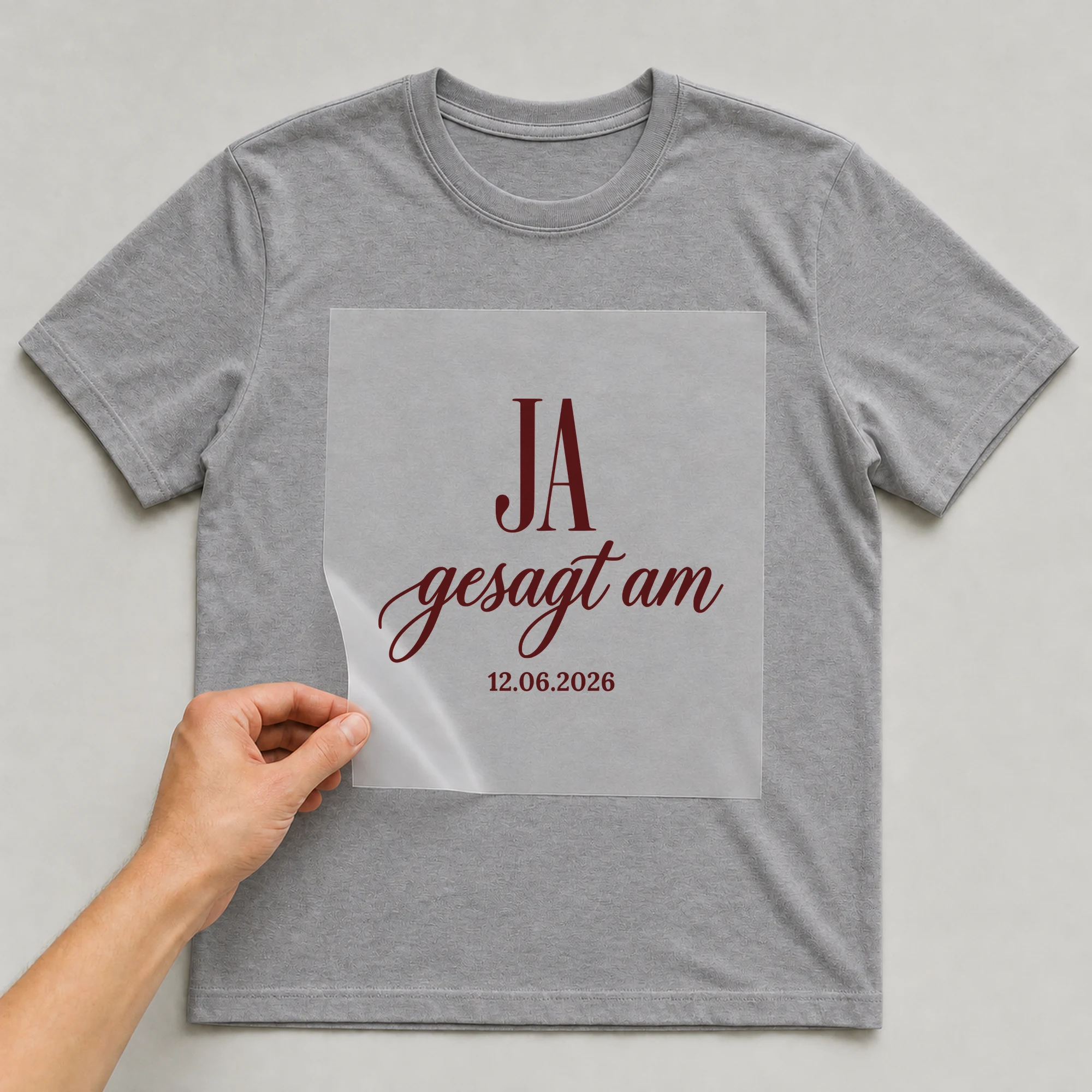 Bügelbild Ja gesagt mit Hochzeitsdatum auf grauem T-Shirt, Folie wird aufgelegt