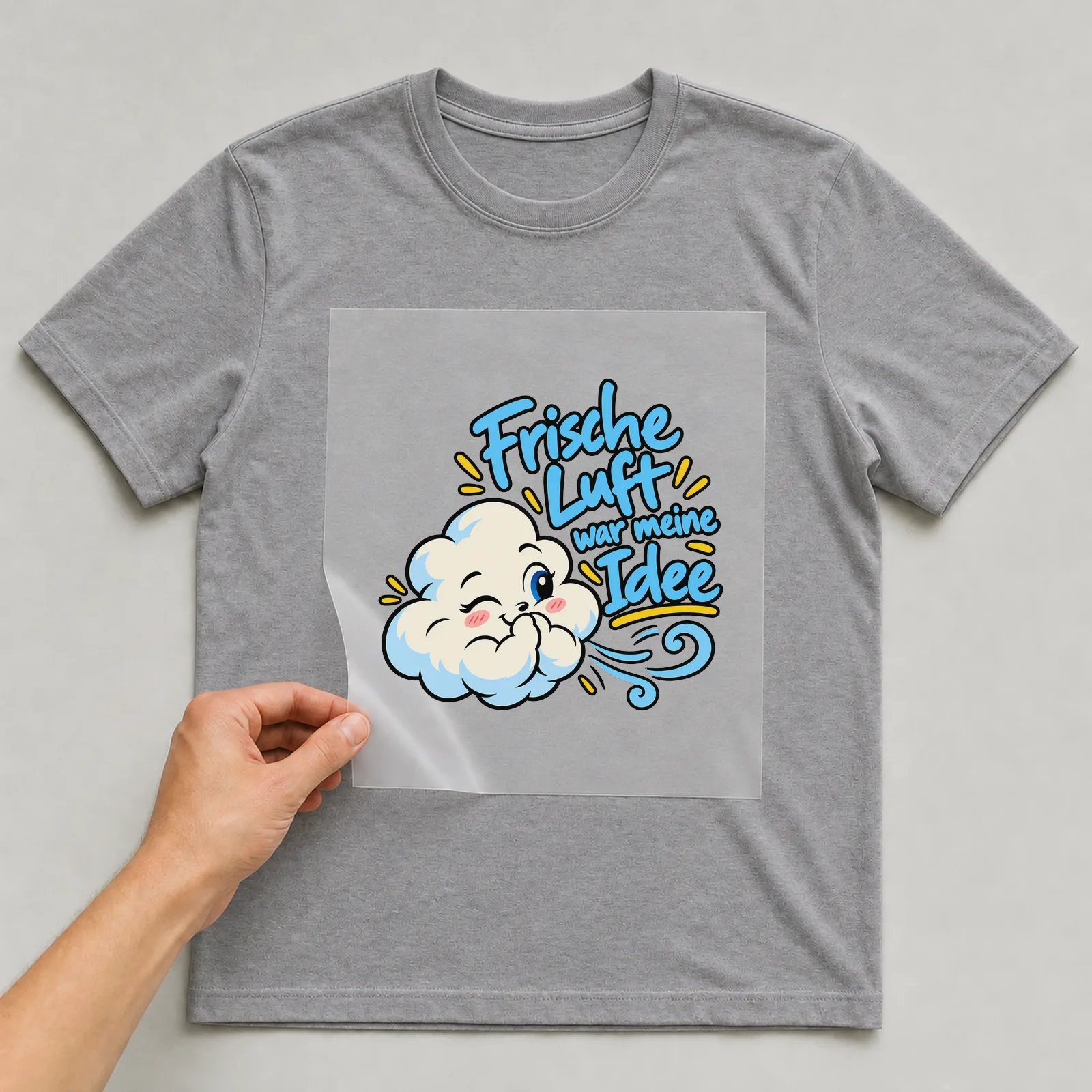 Bügelbild „Frische Luft war meine Idee“ auf grauem T-Shirt, Folie wird aufgelegt