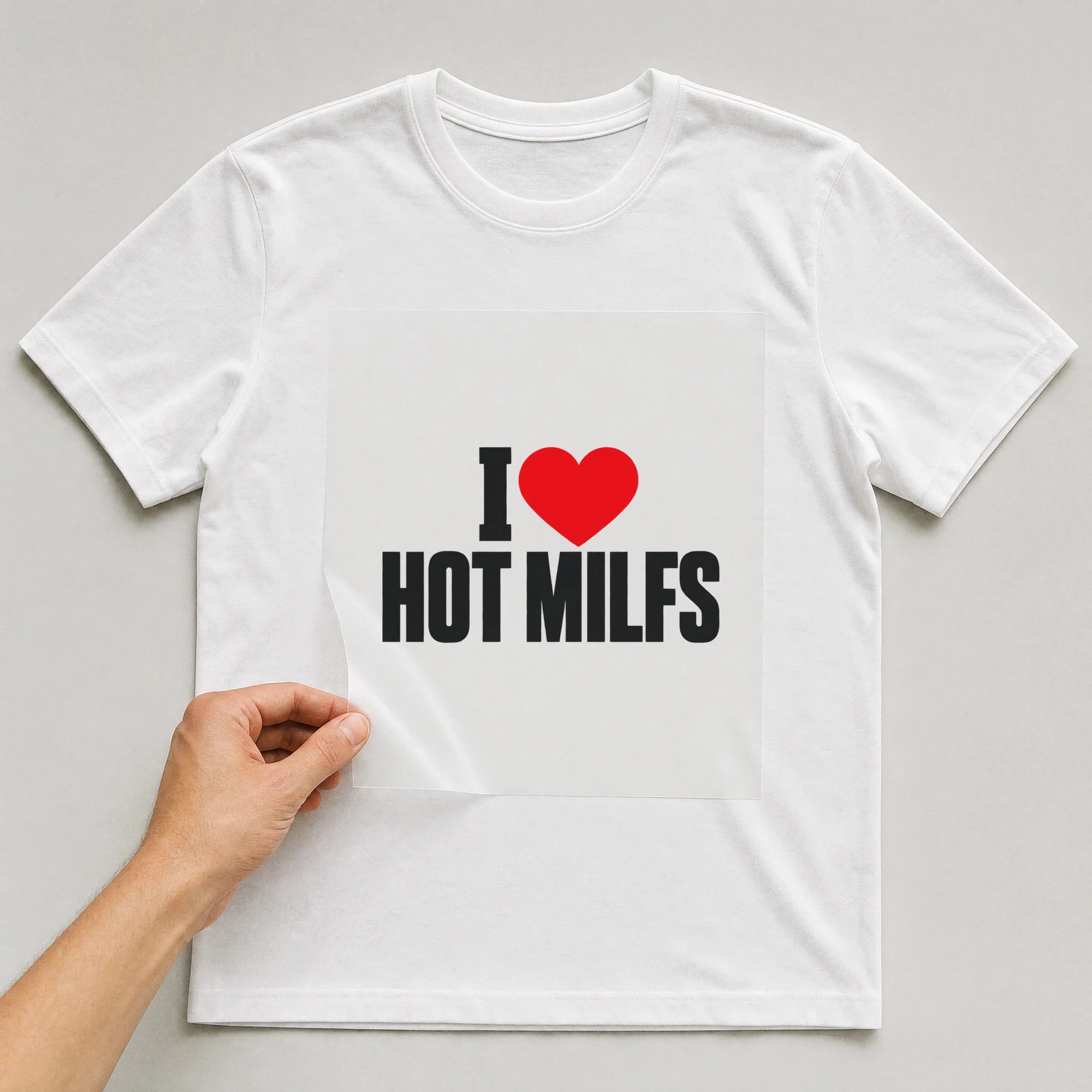 Bügelbild „I Hot Milfs“ auf weißem T-Shirt, Folie wird aufgelegt