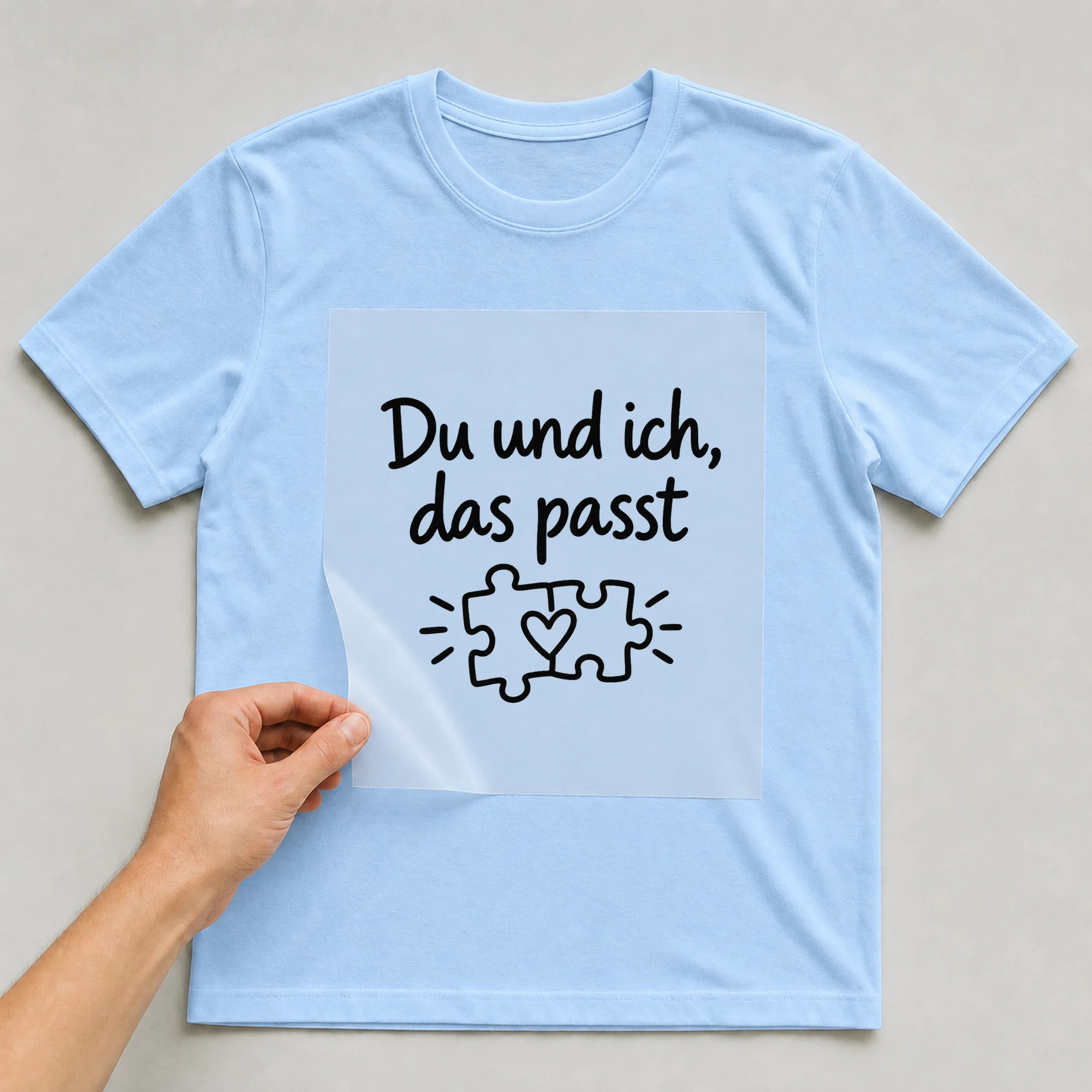 Bügelbild „Du und ich, das passt“ auf babyblauem T-Shirt, Folie wird aufgelegt