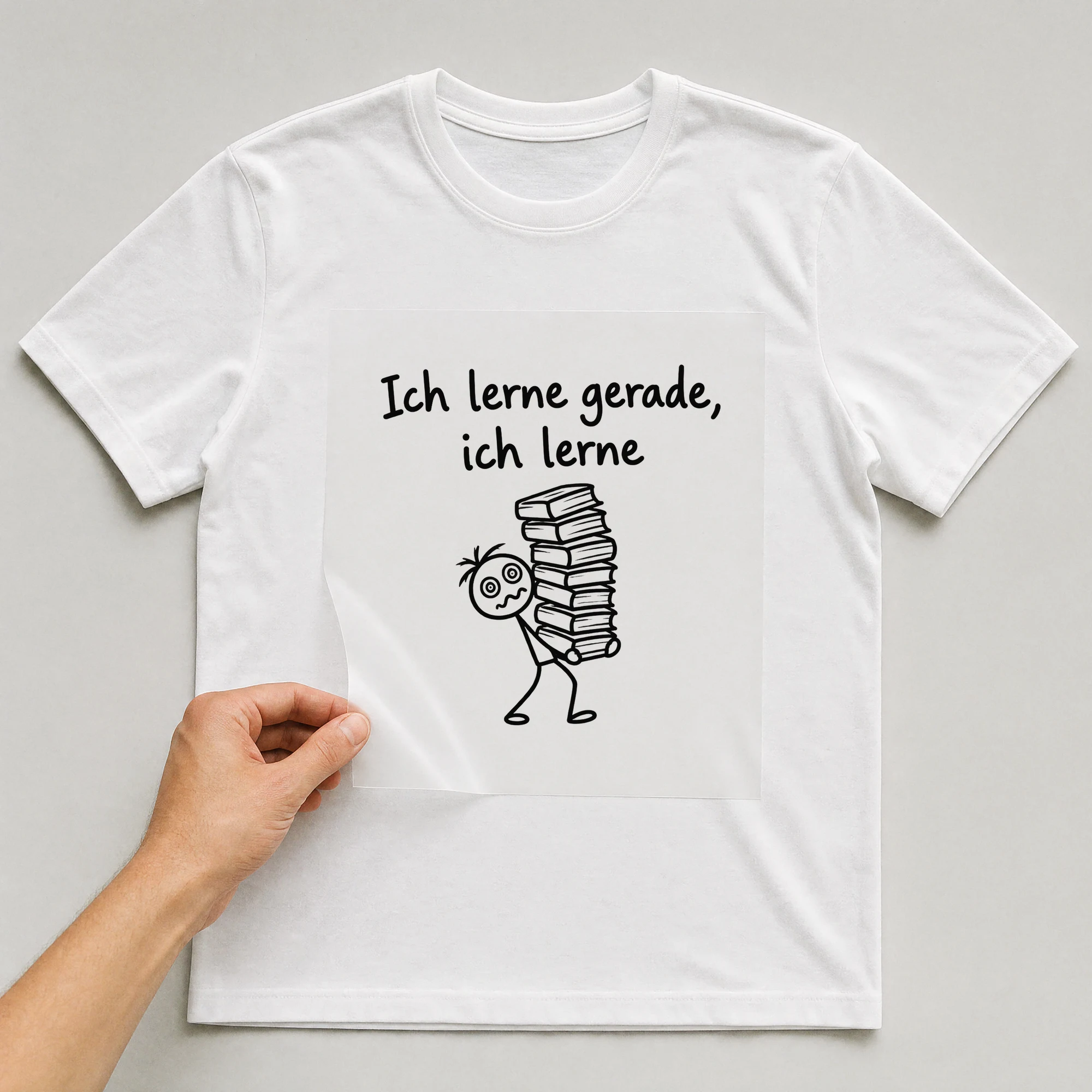 Bügelbild „Ich lerne gerade, ich lerne“ auf weißem T-Shirt, Folie wird aufgelegt