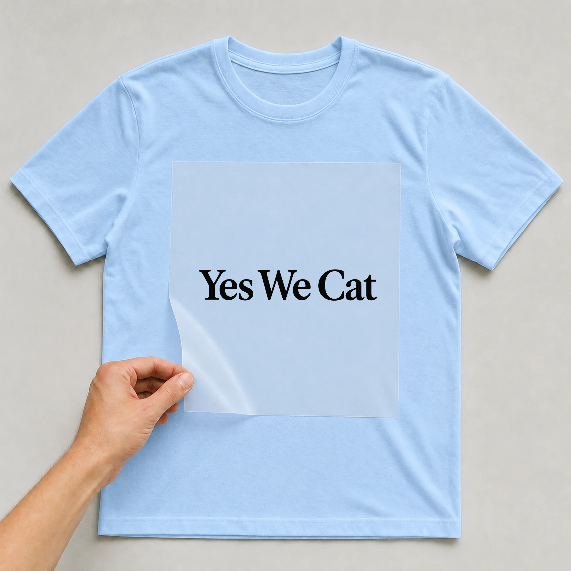 Bügelbild „Yes We Cat“ auf babyblauem T-Shirt, Folie wird aufgelegt