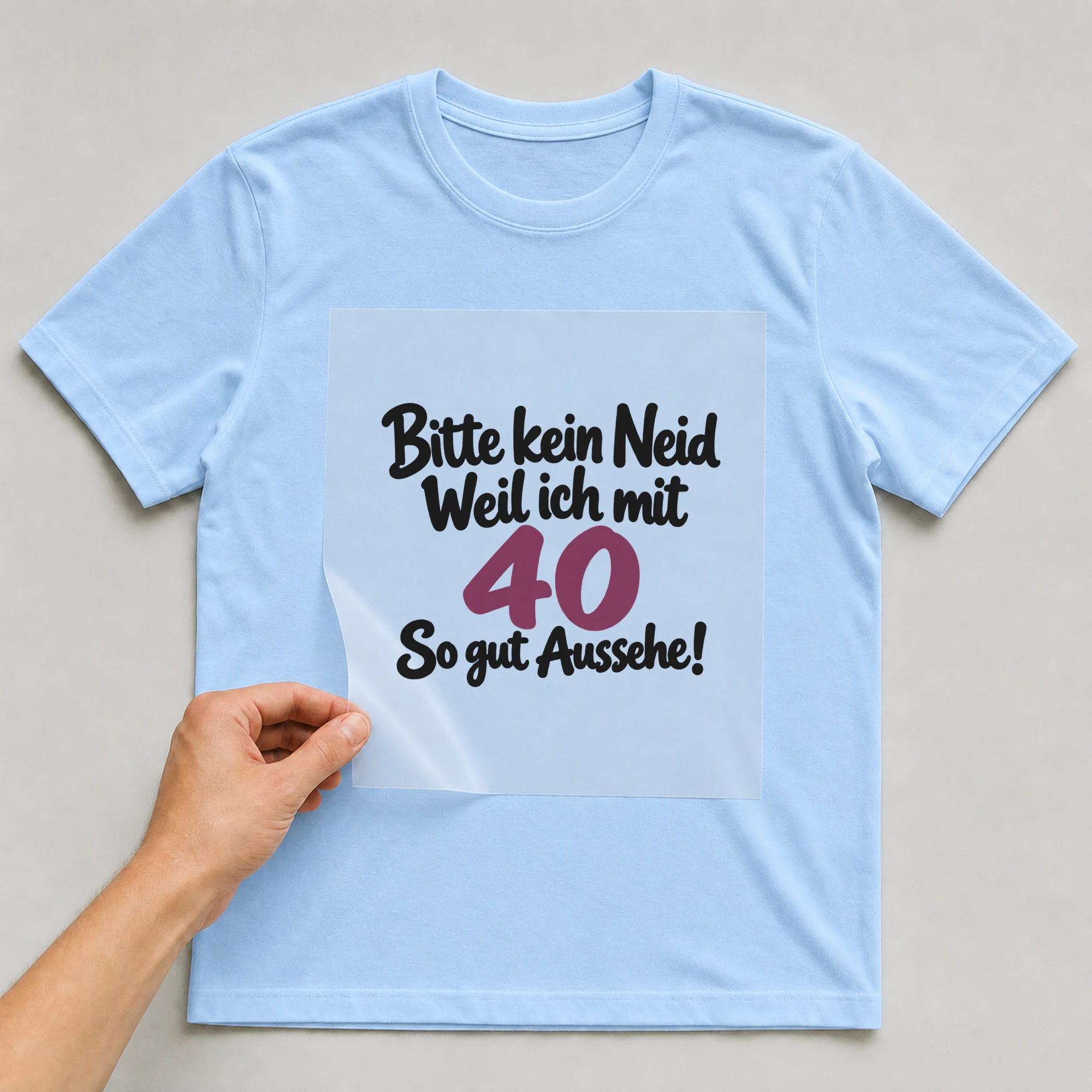Bügelbild „Bitte kein Neid Weil ich mit 40 So gut Aussehe!“ auf babyblauem T-Shirt, Folie wird aufgelegt