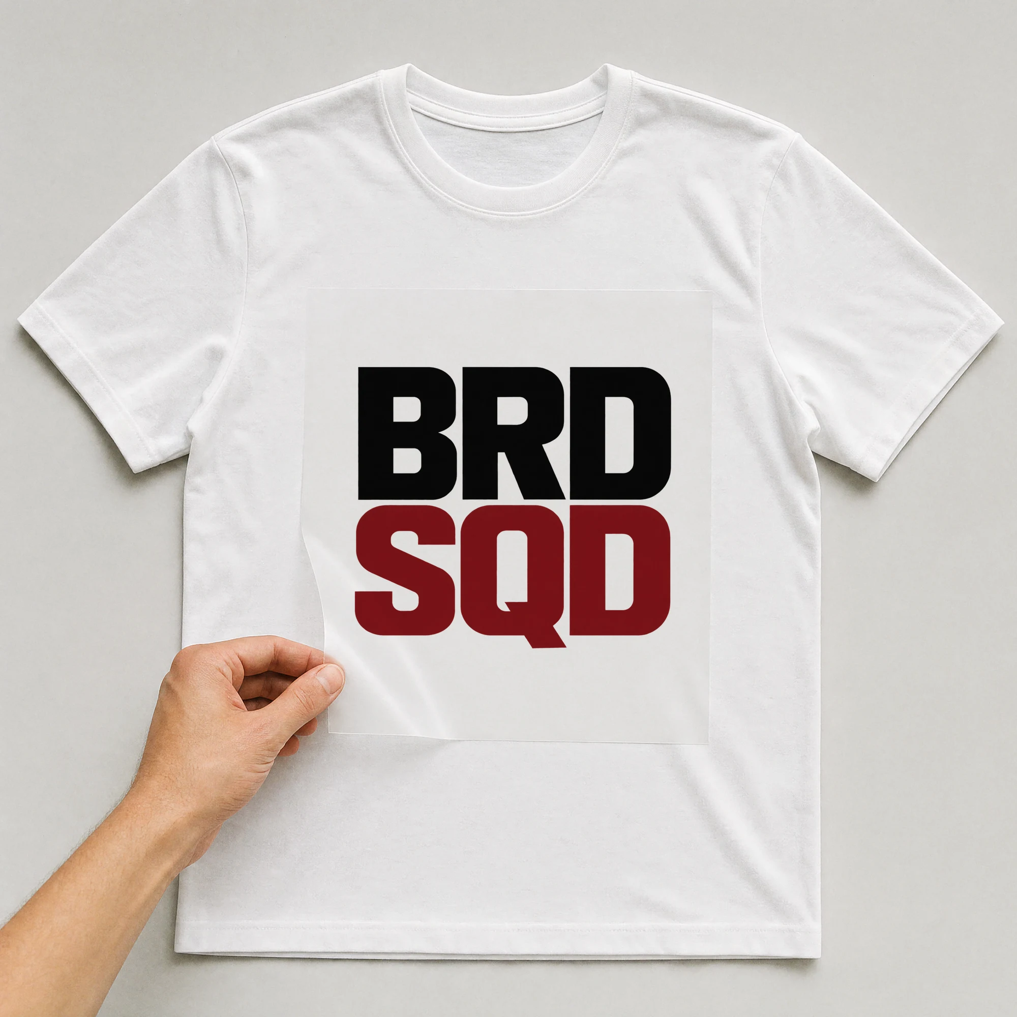 Bügelbild „Brd Sqd“ auf weißem T-Shirt, Folie wird aufgelegt