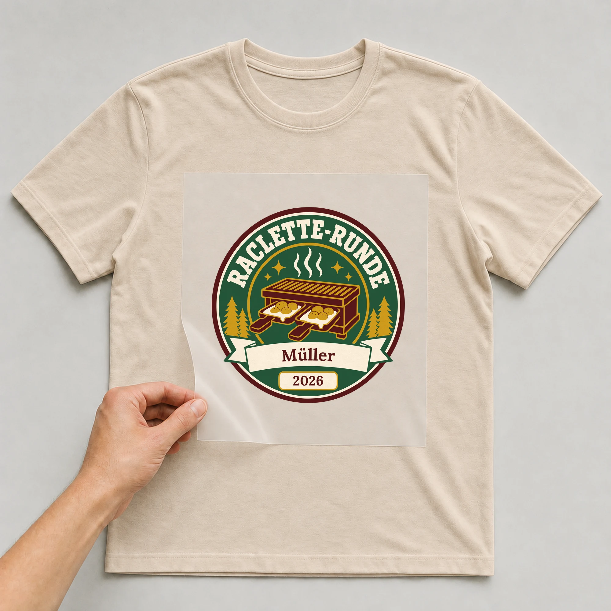 Bügelbild Raclette-Runde mit Nachname und Jahr auf beigem T-Shirt, Folie wird aufgelegt