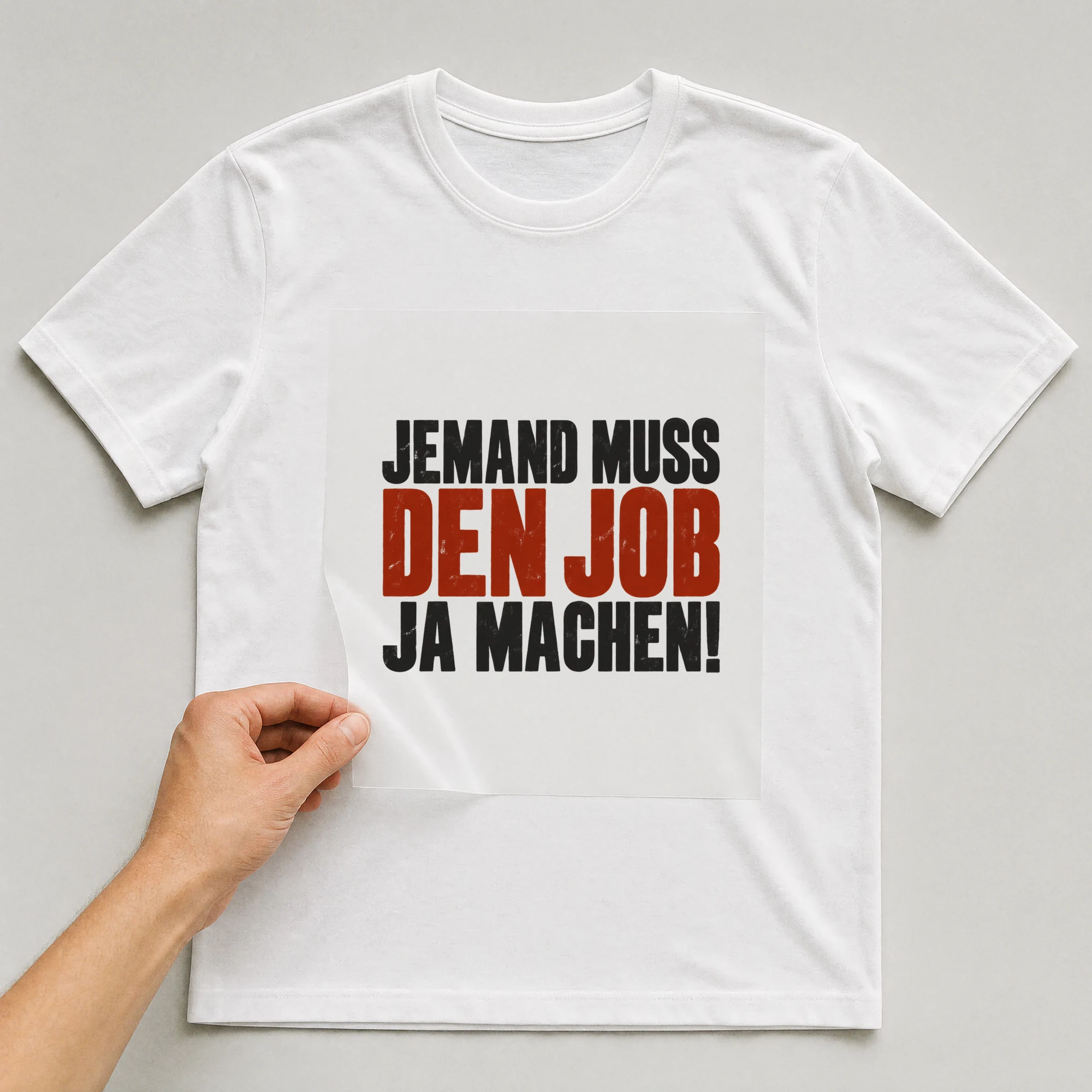 Bügelbild „Jemand muss den Job ja machen!“ auf weißem T-Shirt, Folie wird aufgelegt