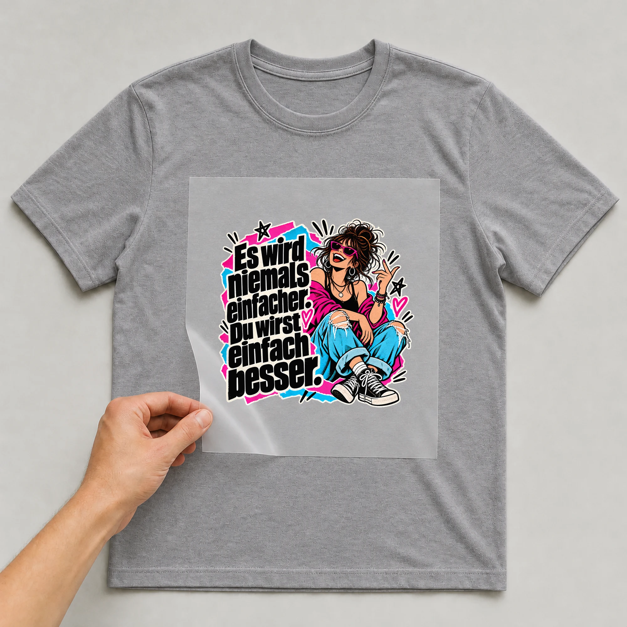 Bügelbild „Es wird niemals einfacher. Du wirst einfach besser.“ auf grauem T-Shirt, Folie wird aufgelegt