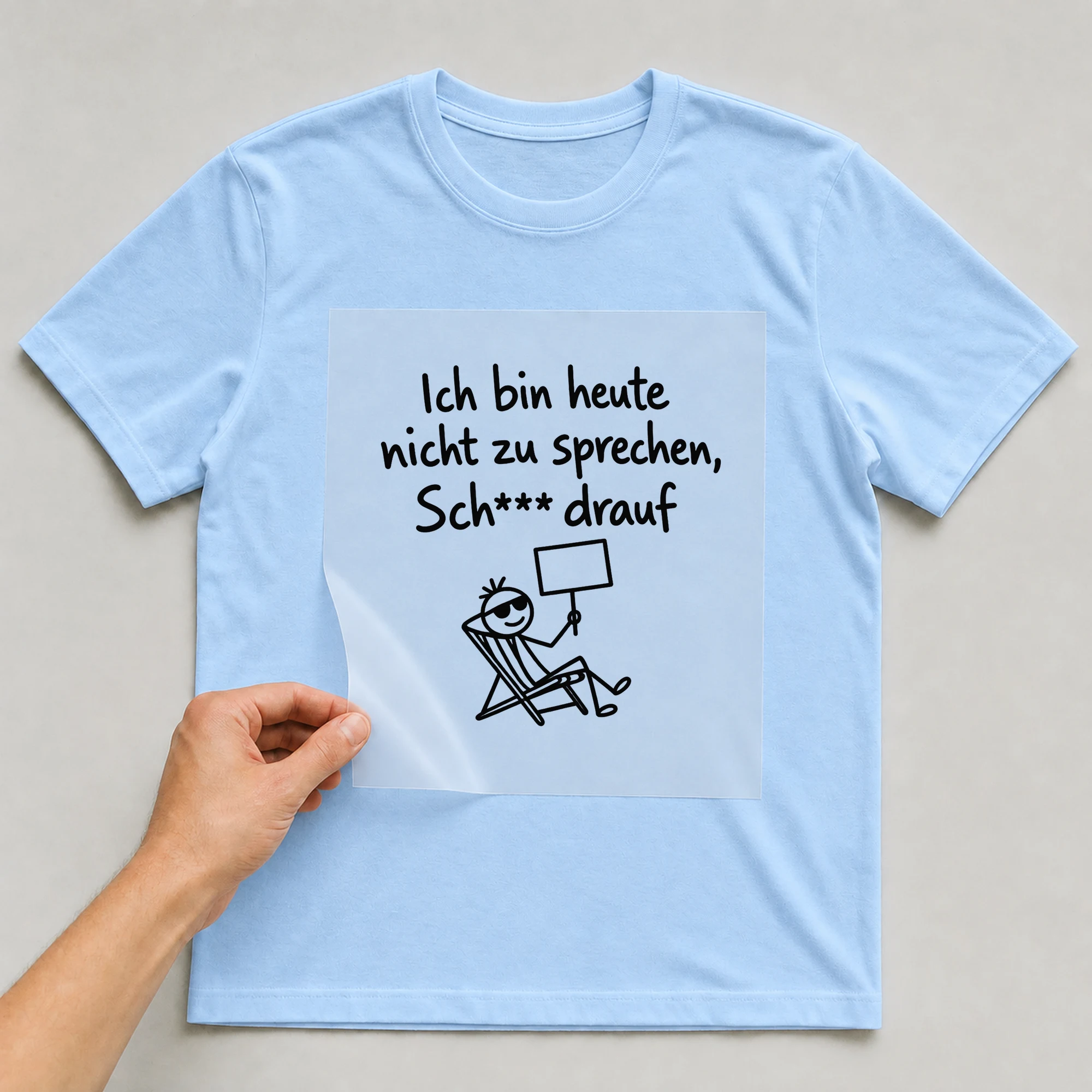 Bügelbild „Ich bin heute nicht zu sprechen, Sch*** drauf“ auf babyblauem T-Shirt, Folie wird aufgelegt