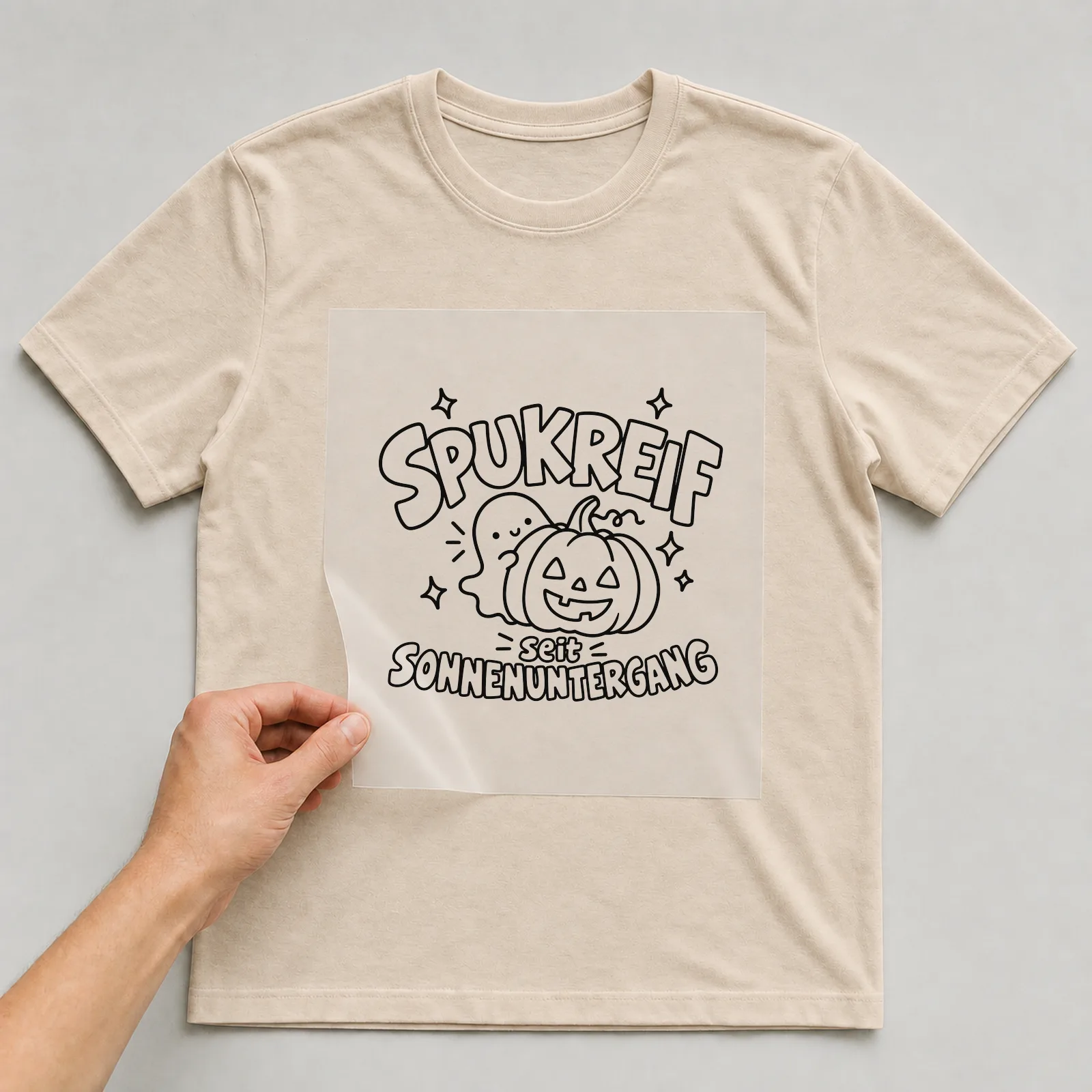 Bügelbild „Spukreif seit Sonnenuntergang“ auf beigem T-Shirt, Folie wird aufgelegt
