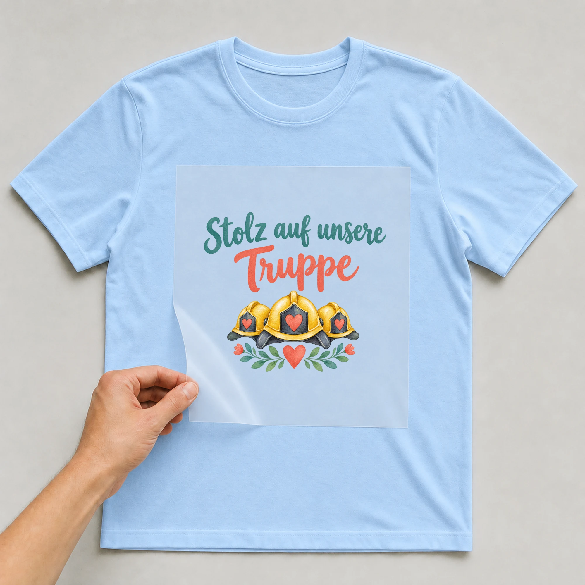 Bügelbild „Stolz auf unsere Truppe“ auf babyblauem T-Shirt, Folie wird aufgelegt