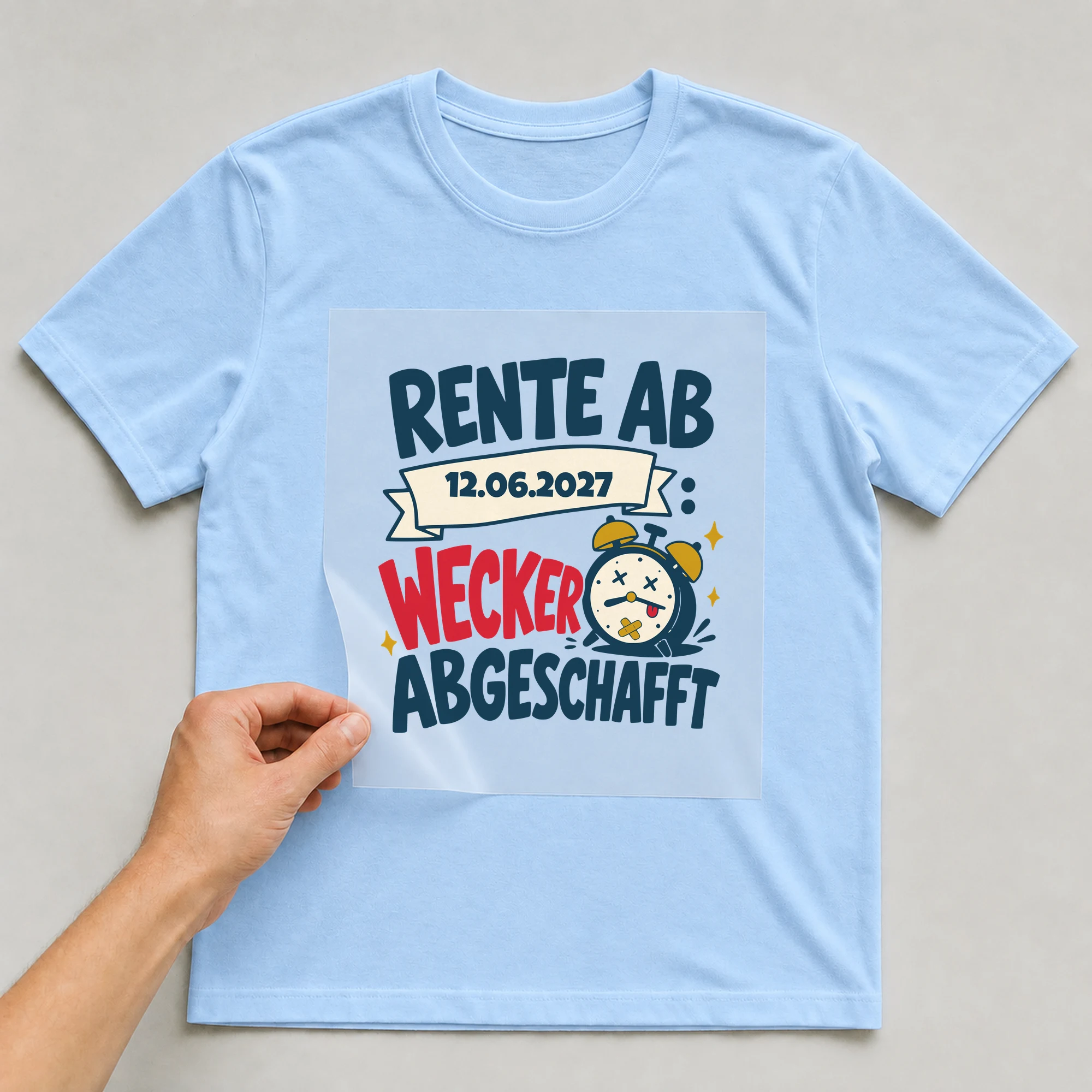 Bügelbild Rente: Wecker abgeschafft mit Datum auf hellblauem T-Shirt, Folie wird aufgelegt