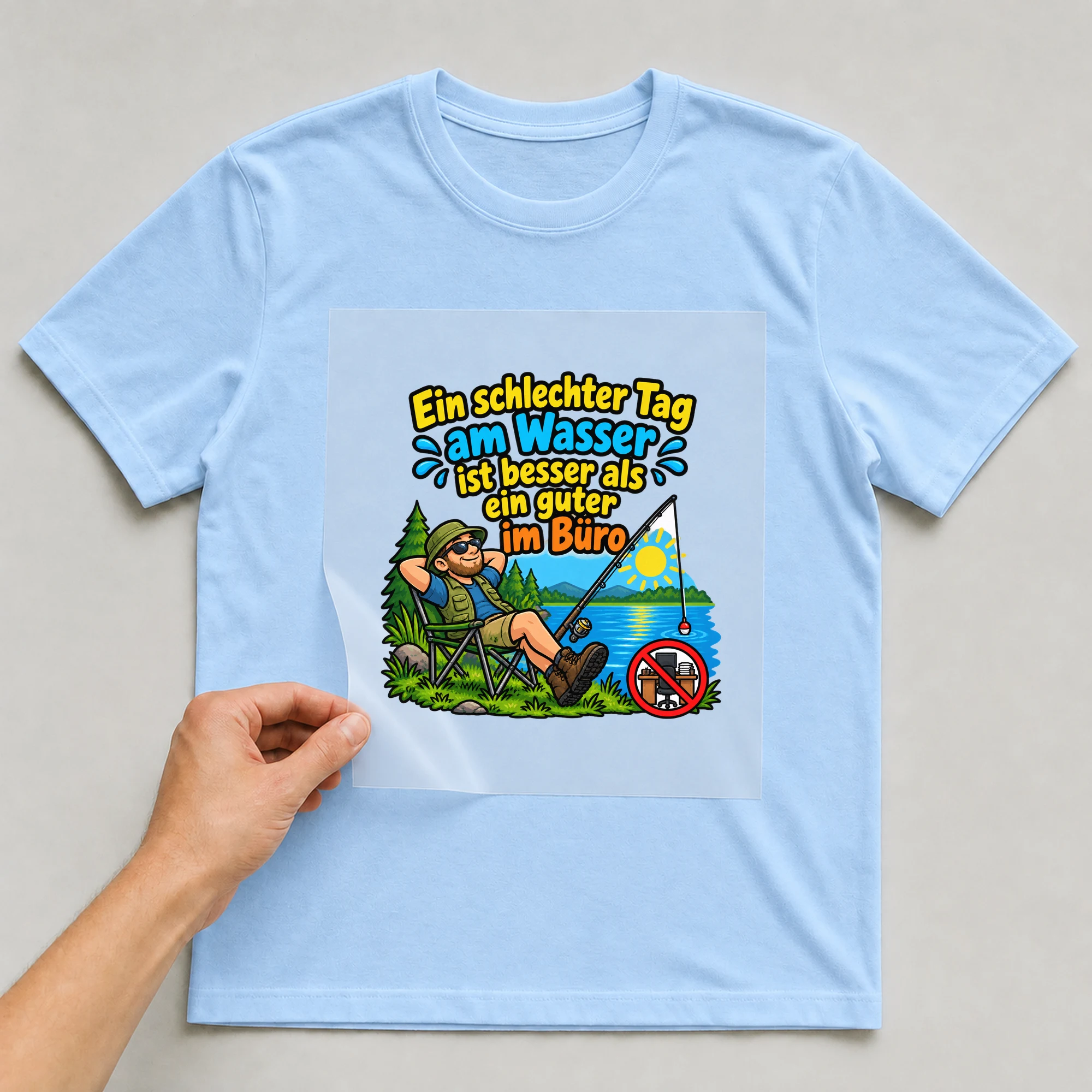 Bügelbild „Ein schlechter Tag am Wasser ist besser als ein guter im Büro“ auf babyblauem T-Shirt, Folie wird aufgelegt