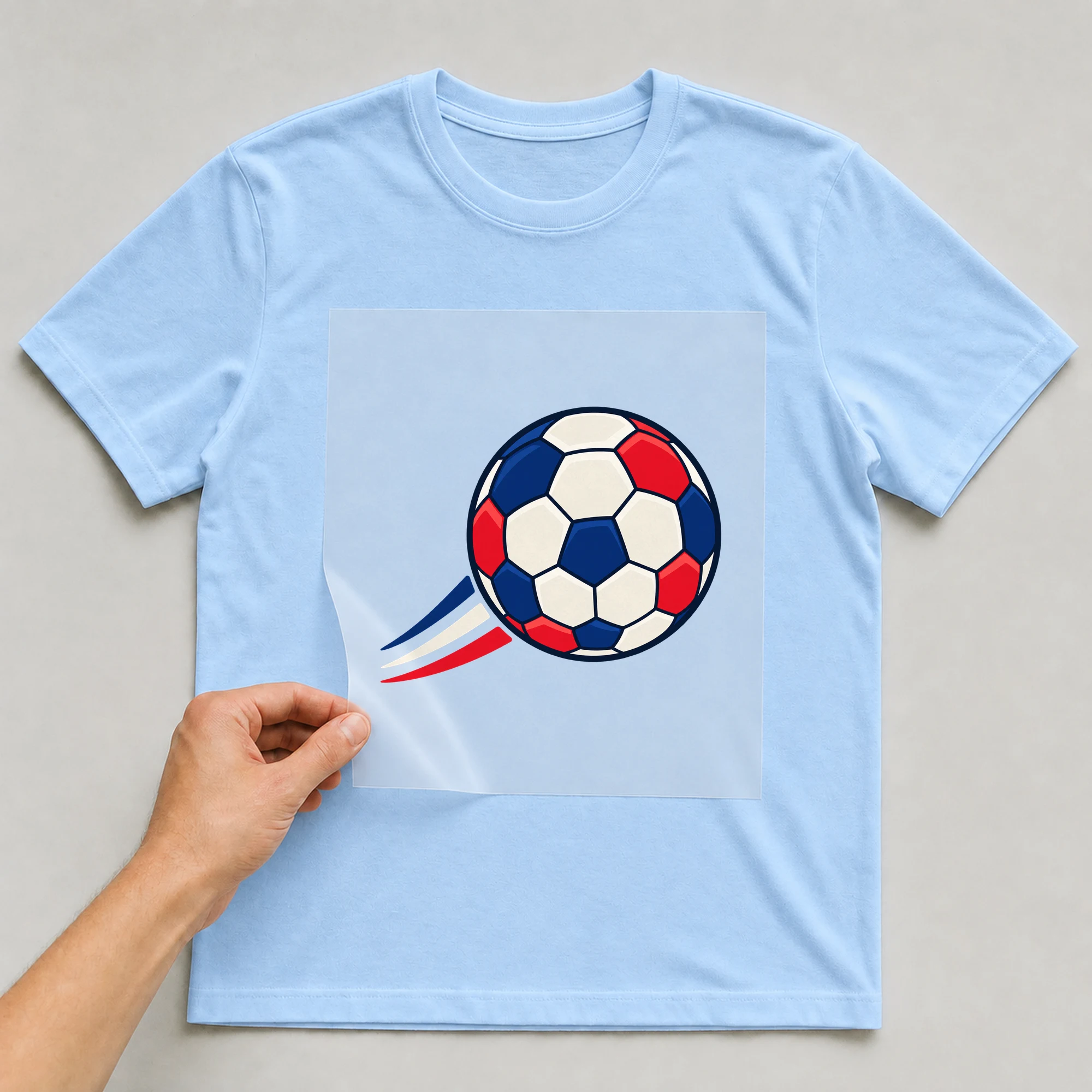 Bügelbild „Fußball Frankreich Ball“ auf babyblauem T-Shirt, Folie wird aufgelegt