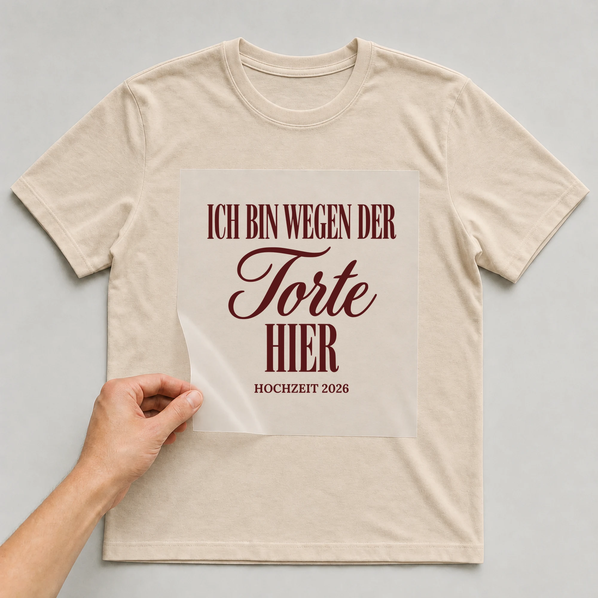 Bügelbild Ich bin wegen der Torte hier auf beigem T-Shirt, Folie wird aufgelegt