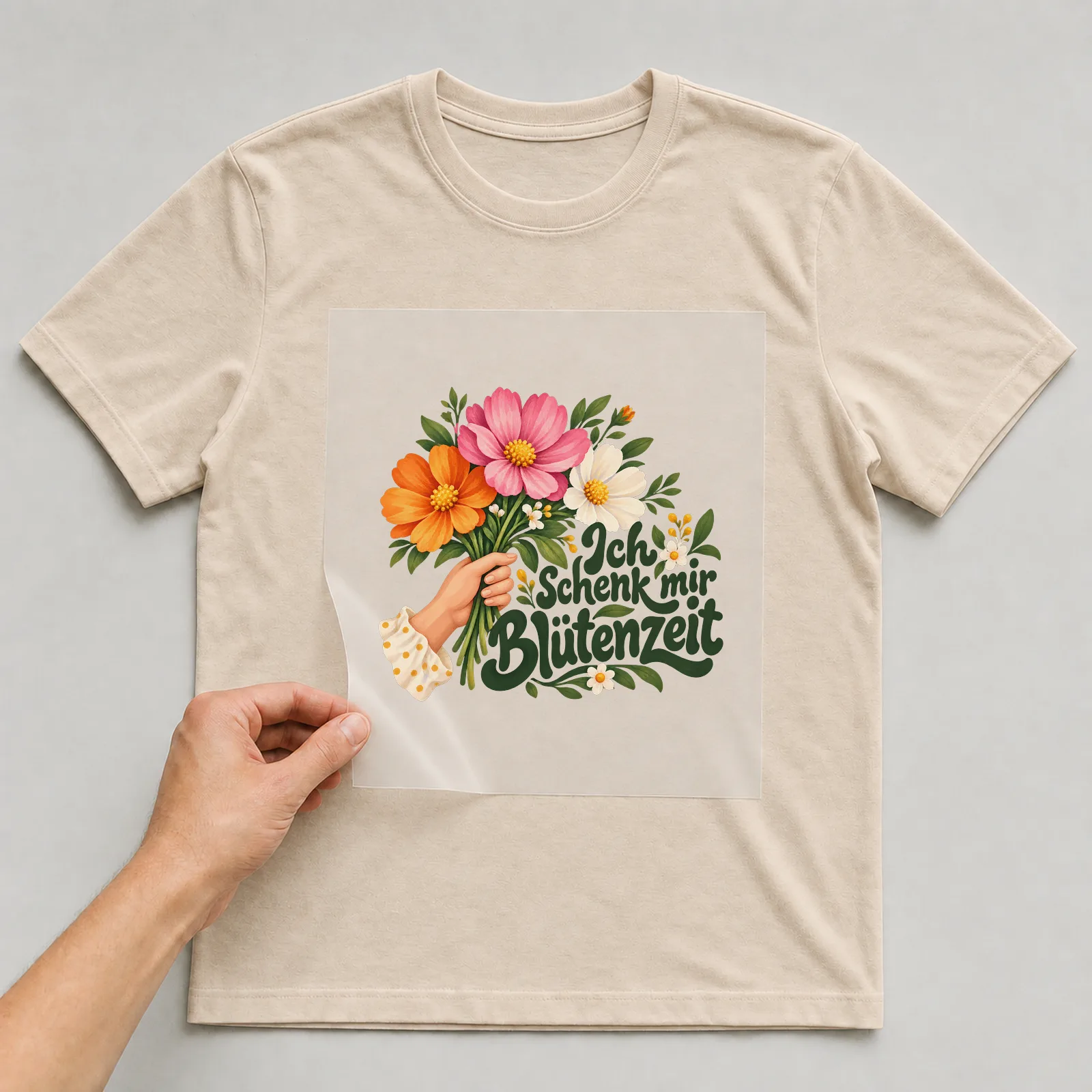 Bügelbild „Ich schenk mir Blütenzeit“ auf beigem T-Shirt, Folie wird aufgelegt