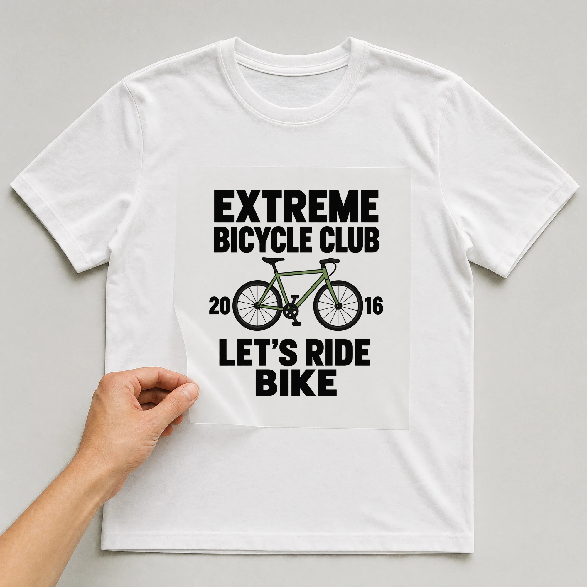 Bügelbild „Extreme Bicycle Club 20 16 Let's Ride Bike“ auf weißem T-Shirt, Folie wird aufgelegt