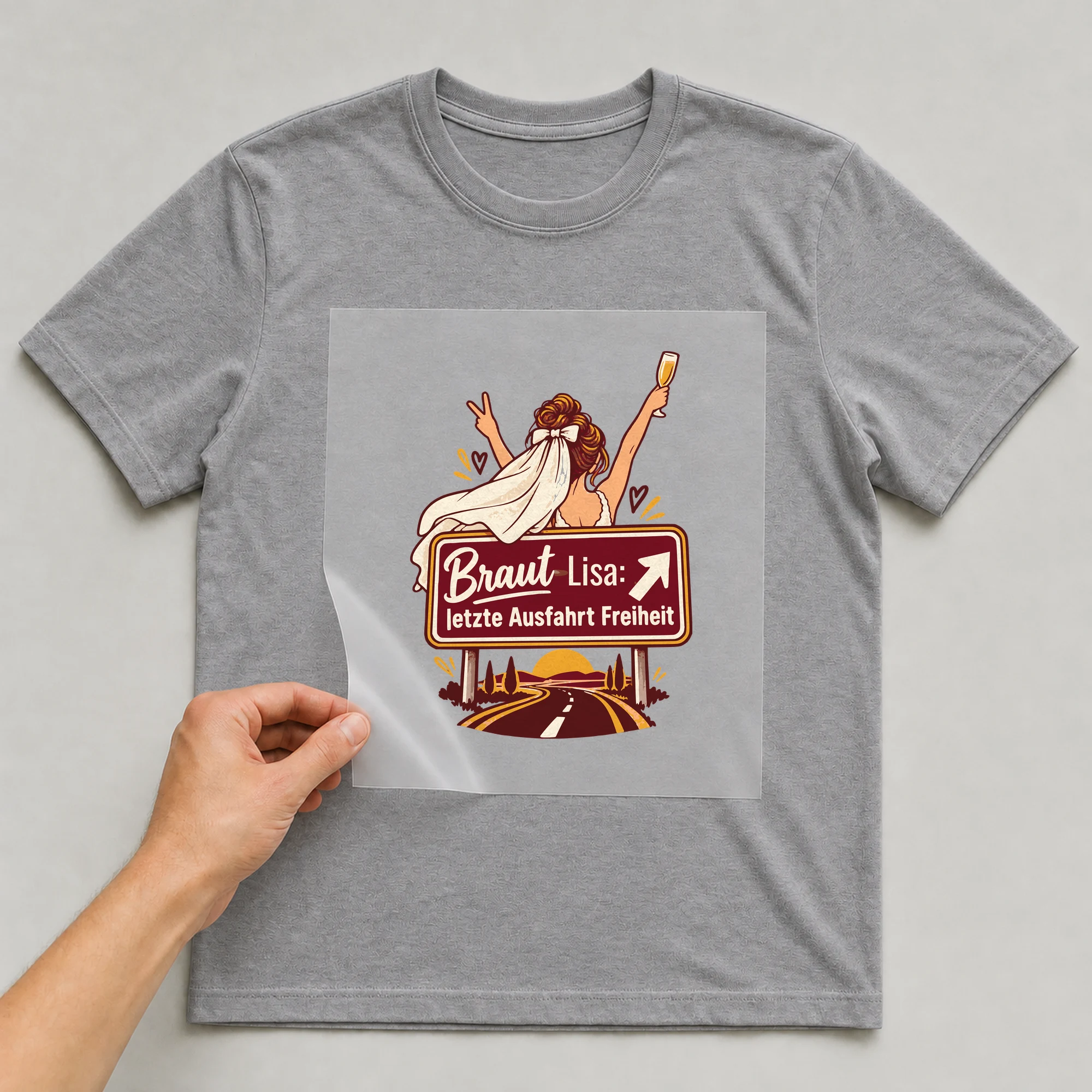 Bügelbild Braut: letzte Ausfahrt Freiheit mit Name auf grauem T-Shirt, Folie wird aufgelegt