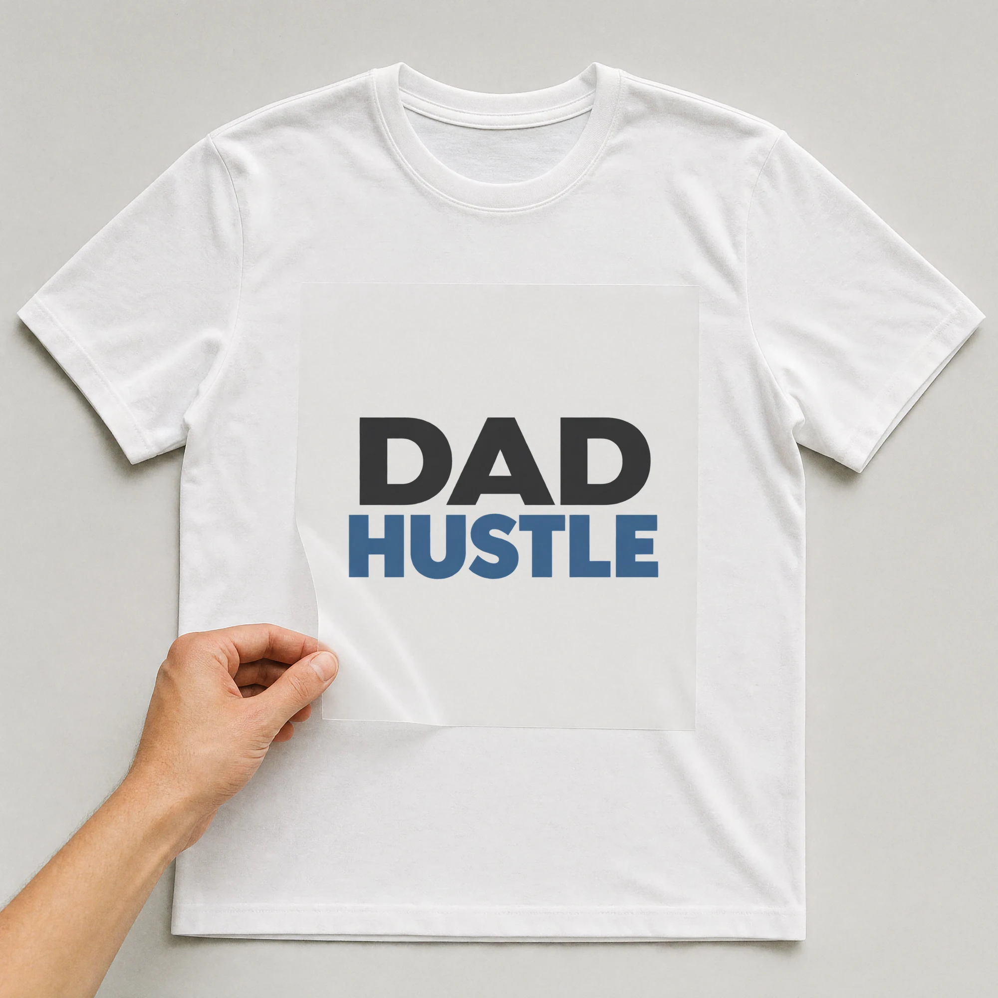 Bügelbild „Dad Hustle“ auf weißem T-Shirt, Folie wird aufgelegt