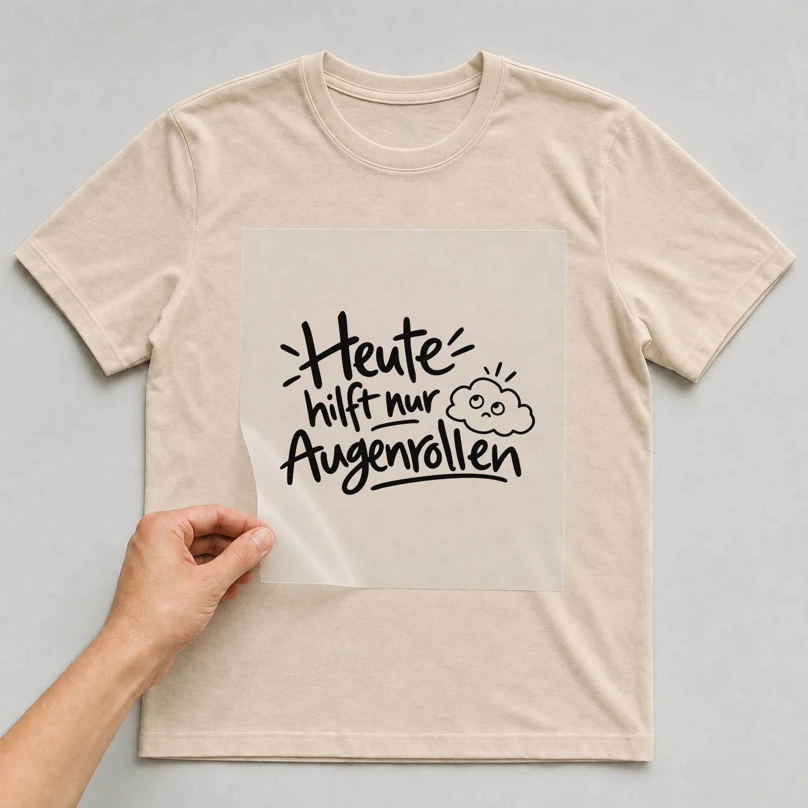 Bügelbild „Heute hilft nur Augenrollen“ auf beigem T-Shirt, Folie wird aufgelegt