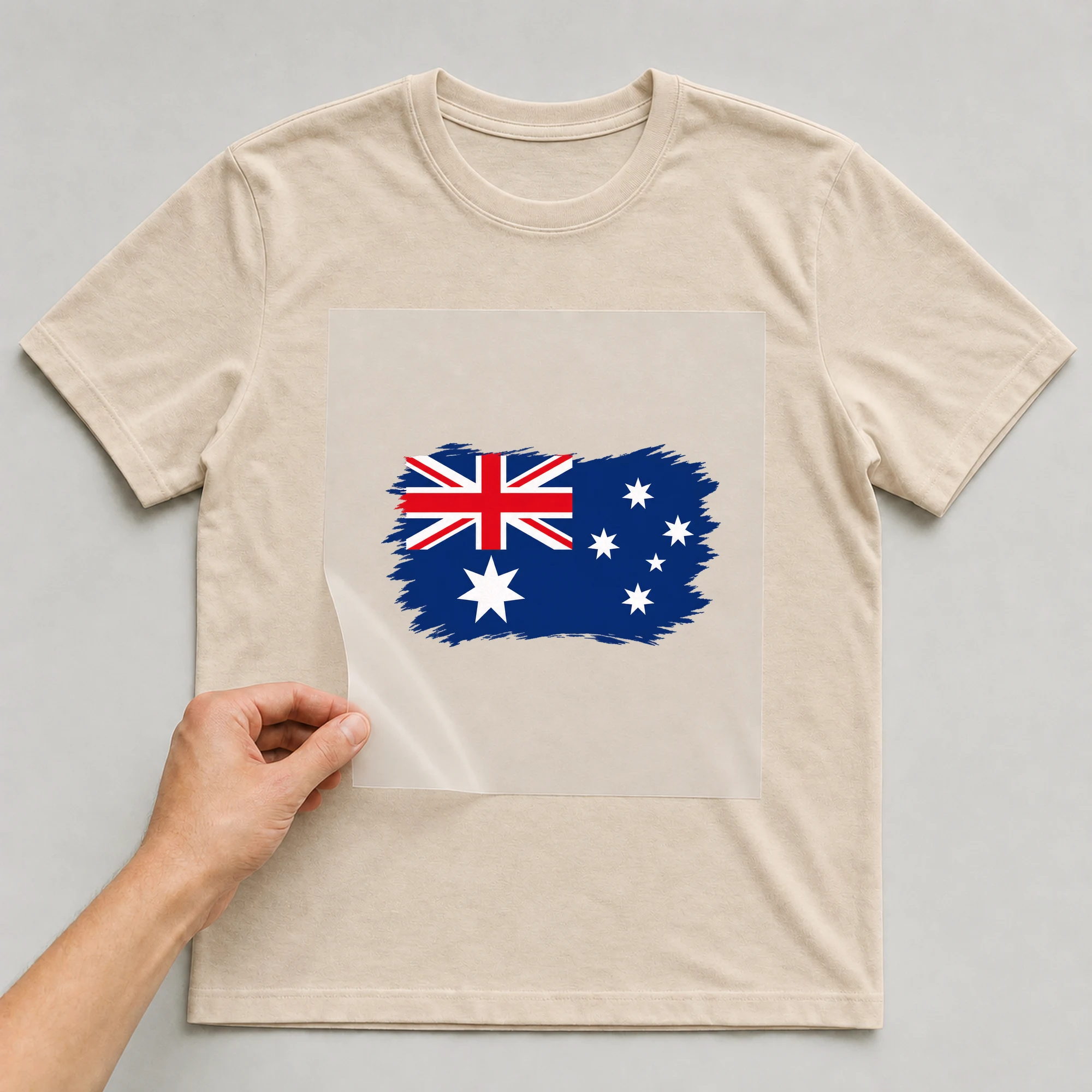 Bügelbild „Flagge Australien im Pinselstrich“ auf beigem T-Shirt, Folie wird aufgelegt