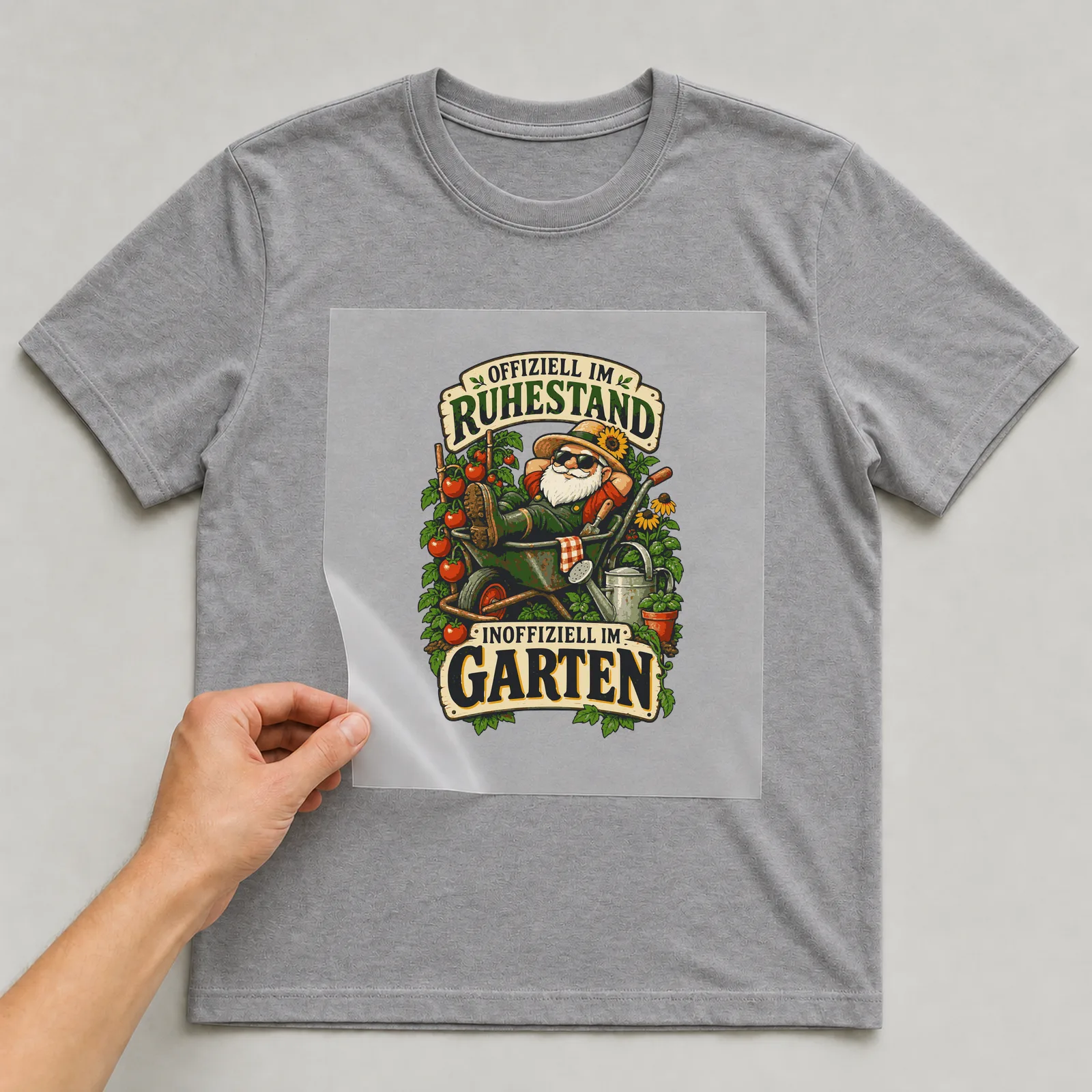 Bügelbild Offiziell im Ruhestand, inoffiziell im Garten auf grauem T-Shirt, Folie wird aufgelegt