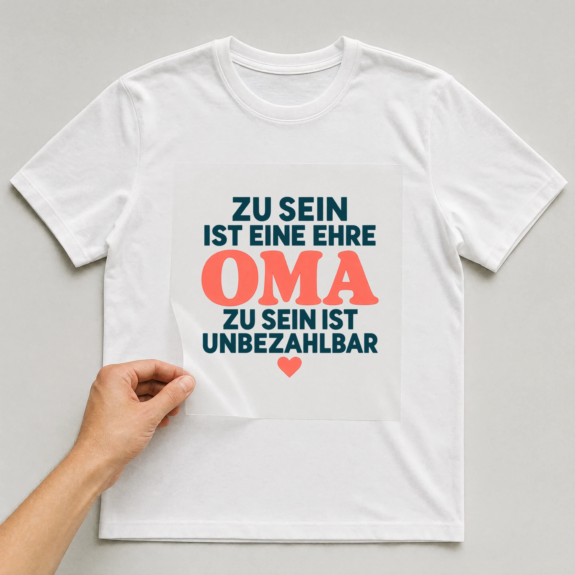 Bügelbild „Zu sein ist eine Ehre Oma zu sein ist unbezahlbar“ auf weißem T-Shirt, Folie wird aufgelegt