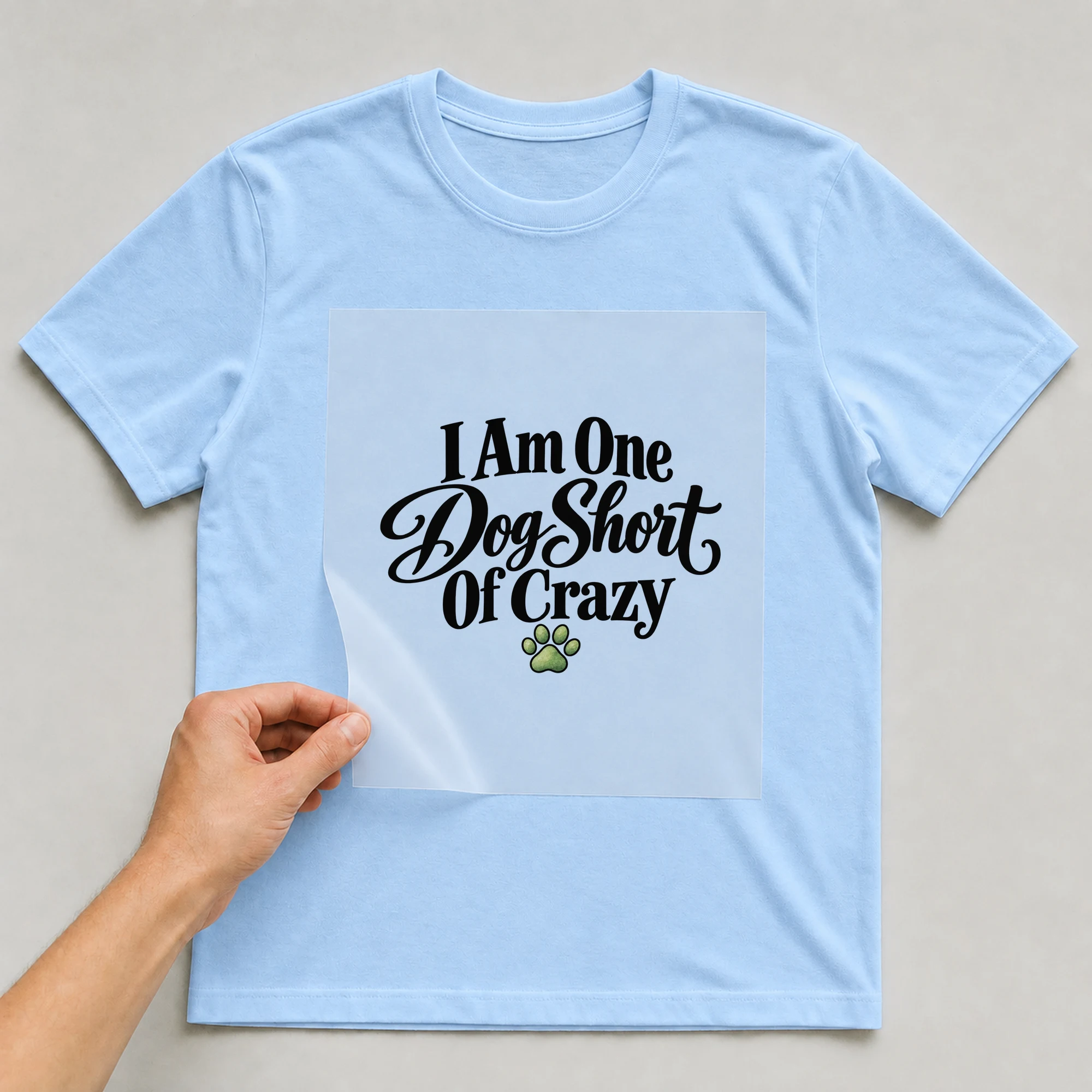 Bügelbild „I Am One Dog Short Of Crazy“ auf babyblauem T-Shirt, Folie wird aufgelegt