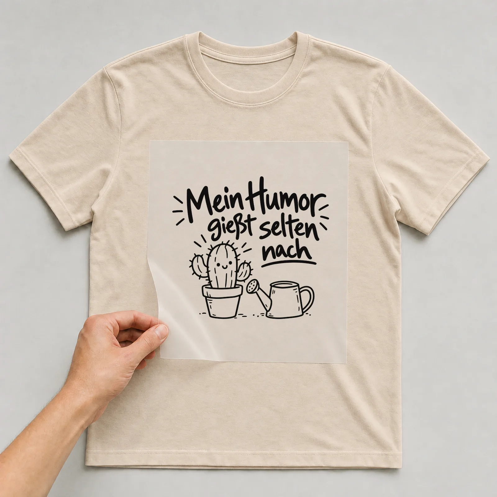 Bügelbild „Mein Humor gießt selten nach“ auf beigem T-Shirt, Folie wird aufgelegt