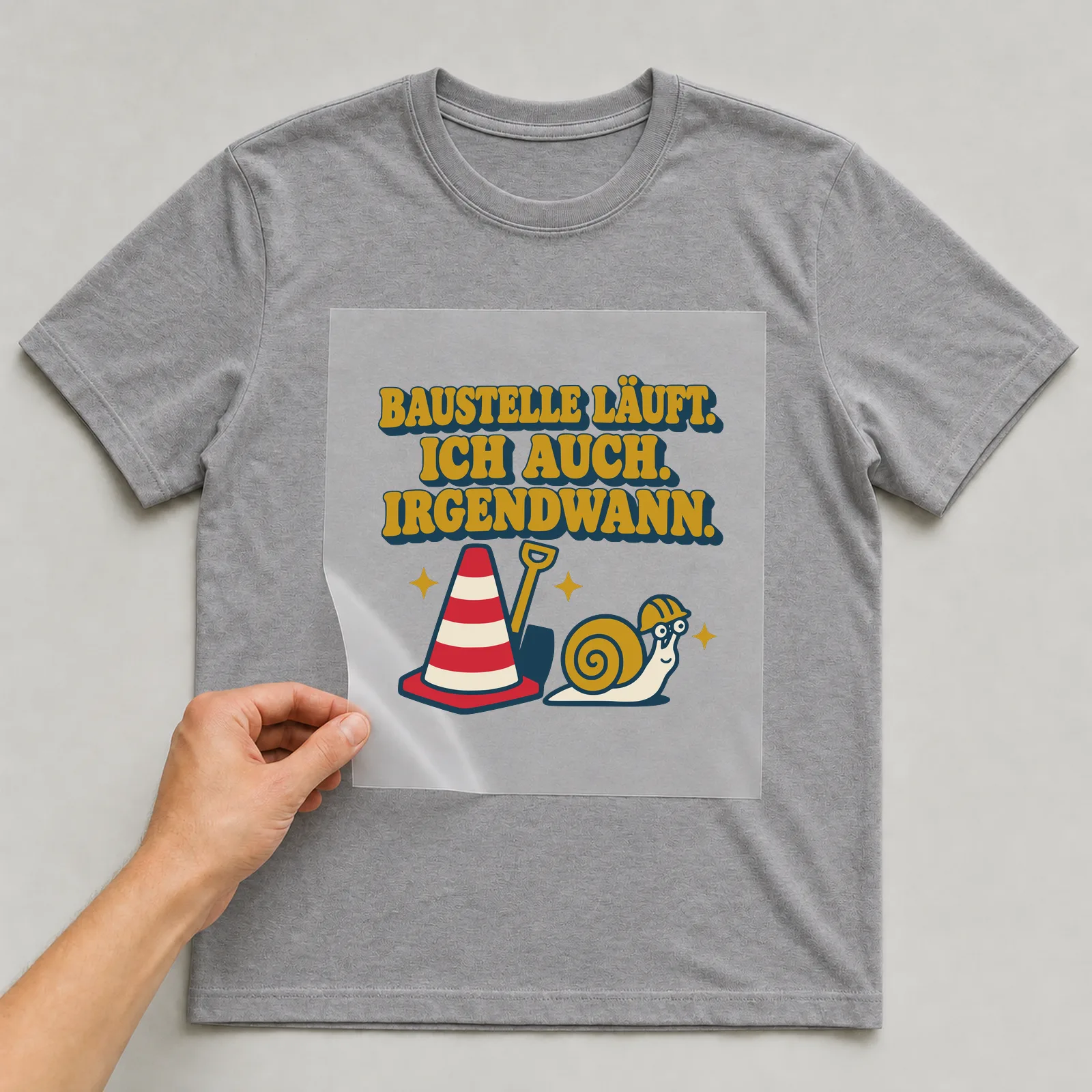 Bügelbild Baustelle läuft. Ich auch. Irgendwann. auf grauem T-Shirt, Folie wird aufgelegt