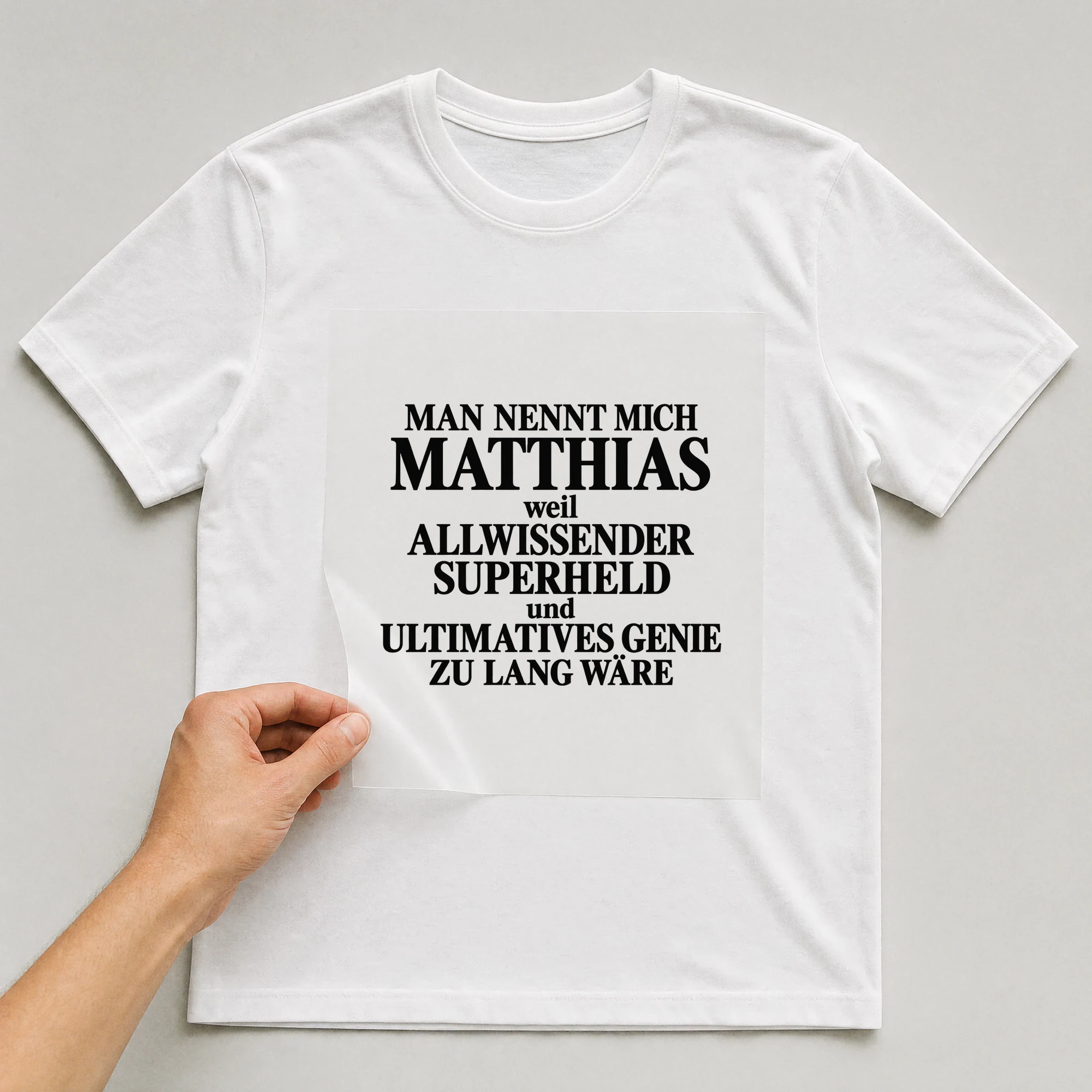 Bügelbild „Man nennt mich Matthias weil allwissender Superheld und ultimatives Genie zu“ auf weißem T-Shirt, Folie wird aufgelegt