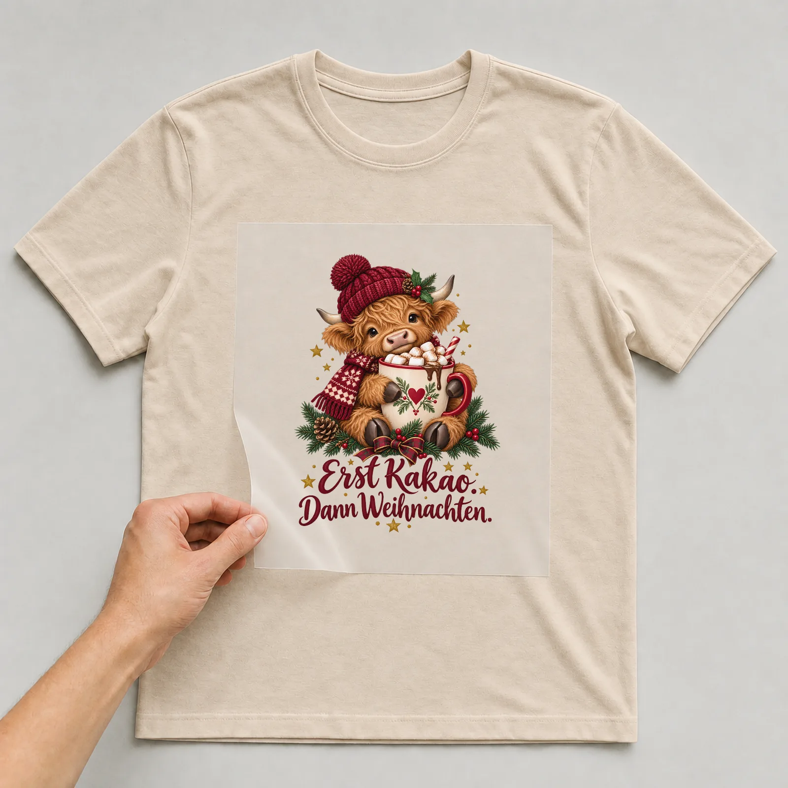 Bügelbild Erst Kakao. Dann Weihnachten. auf beigem T-Shirt, Folie wird aufgelegt