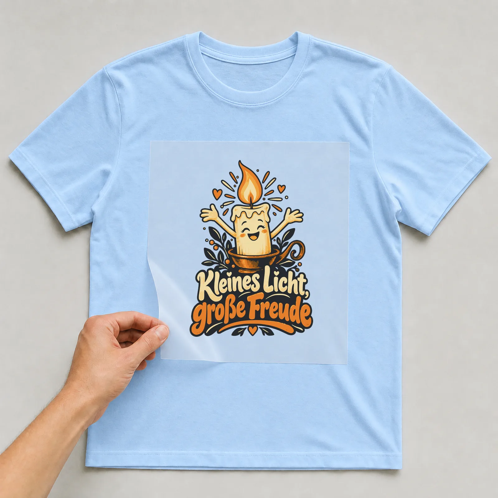 Bügelbild Kleines Licht, große Freude auf hellblauem T-Shirt, Folie wird aufgelegt