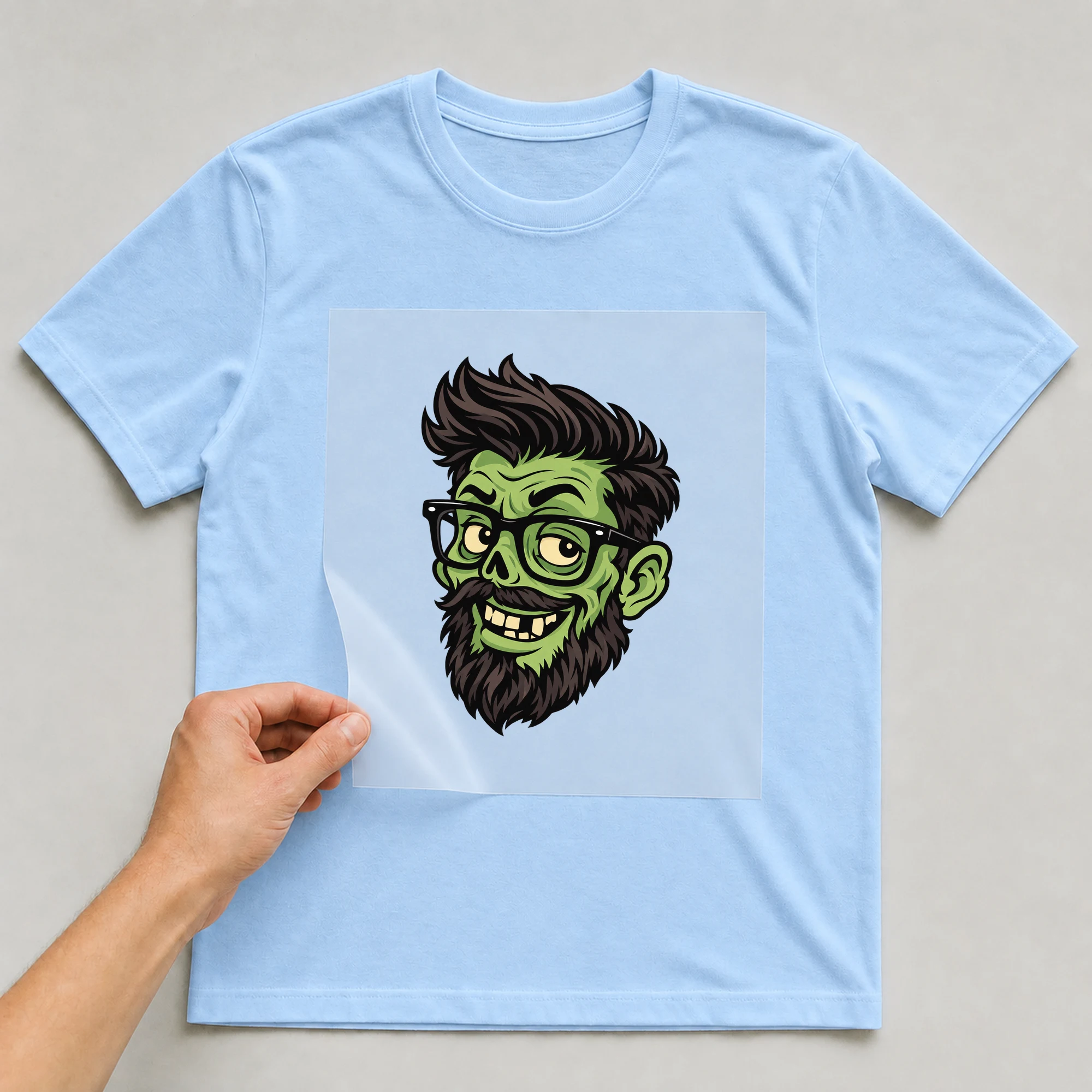 Bügelbild „Zombie Head“ auf babyblauem T-Shirt, Folie wird aufgelegt