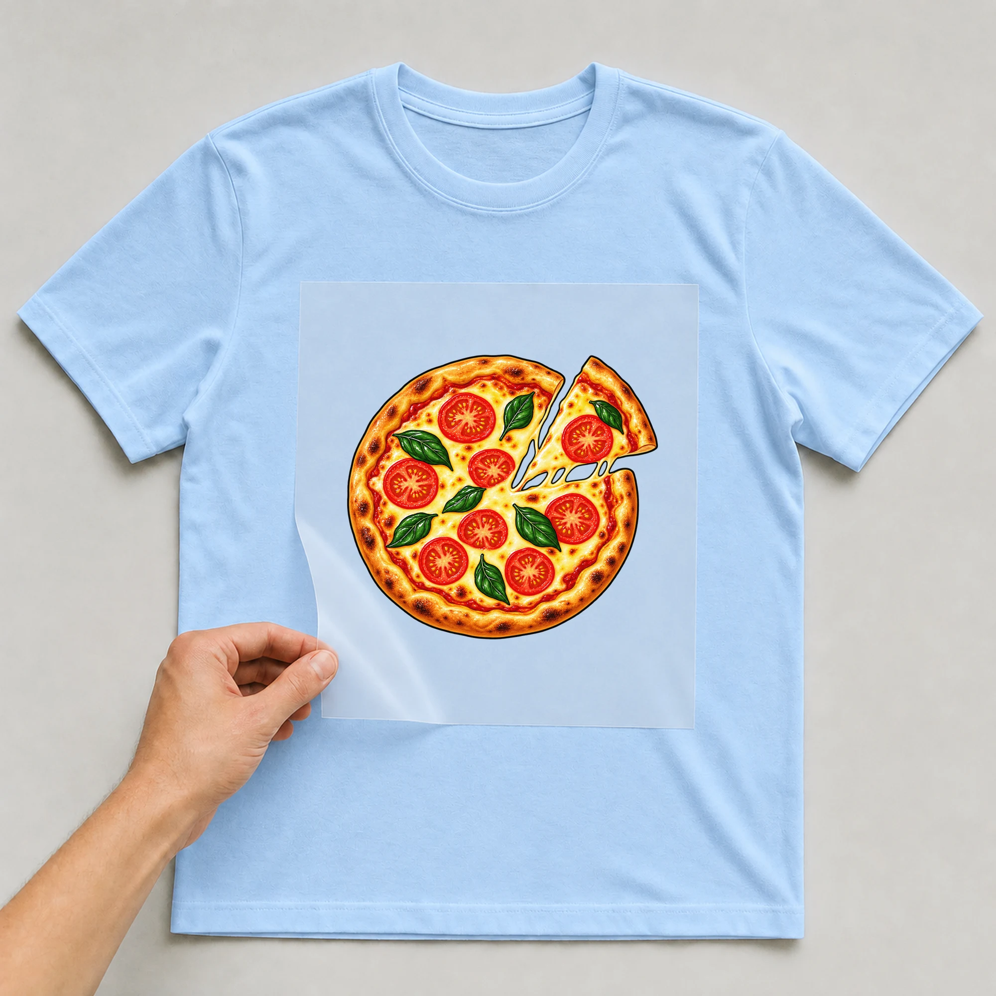 Bügelbild „Pizza“ auf babyblauem T-Shirt, Folie wird aufgelegt