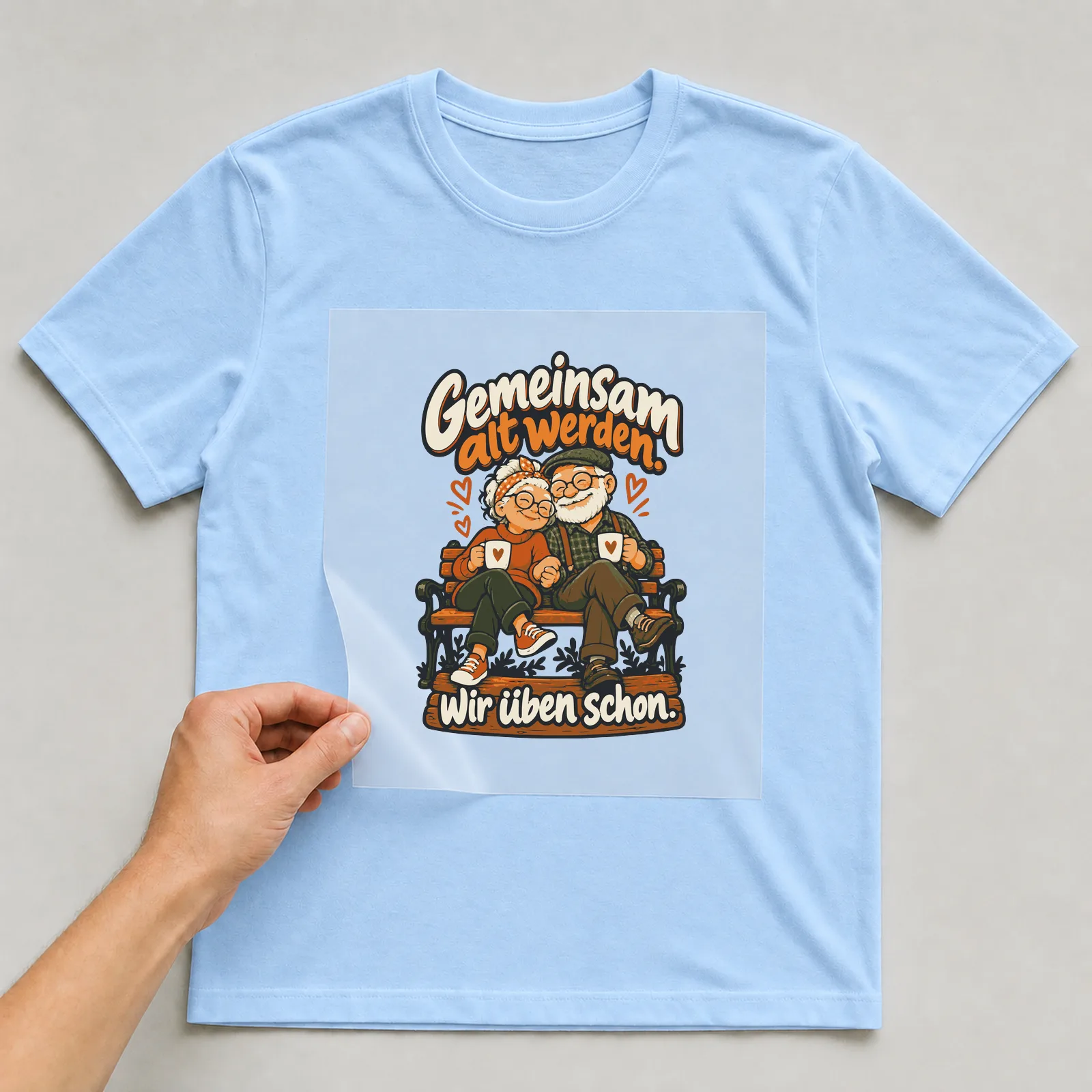 Bügelbild Gemeinsam alt werden. Wir üben schon. auf hellblauem T-Shirt, Folie wird aufgelegt