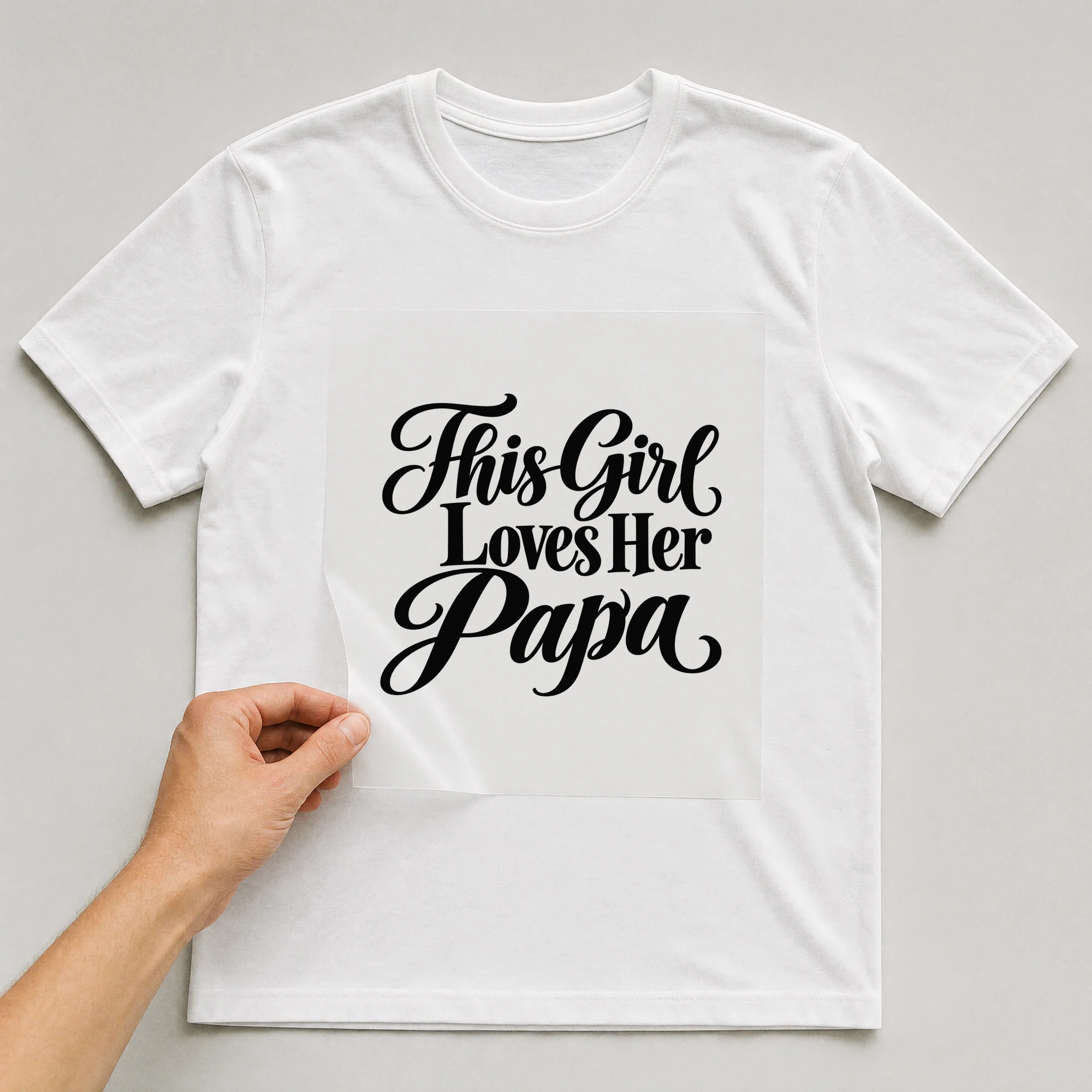 Bügelbild „This Girl Loves Her Papa“ auf weißem T-Shirt, Folie wird aufgelegt
