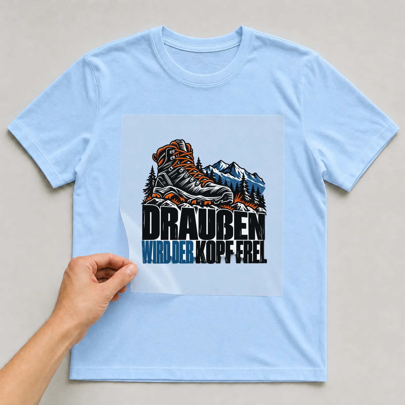 Bügelbild „Draußen wird der Kopf frei“ auf hellblauem T-Shirt, Folie wird aufgelegt