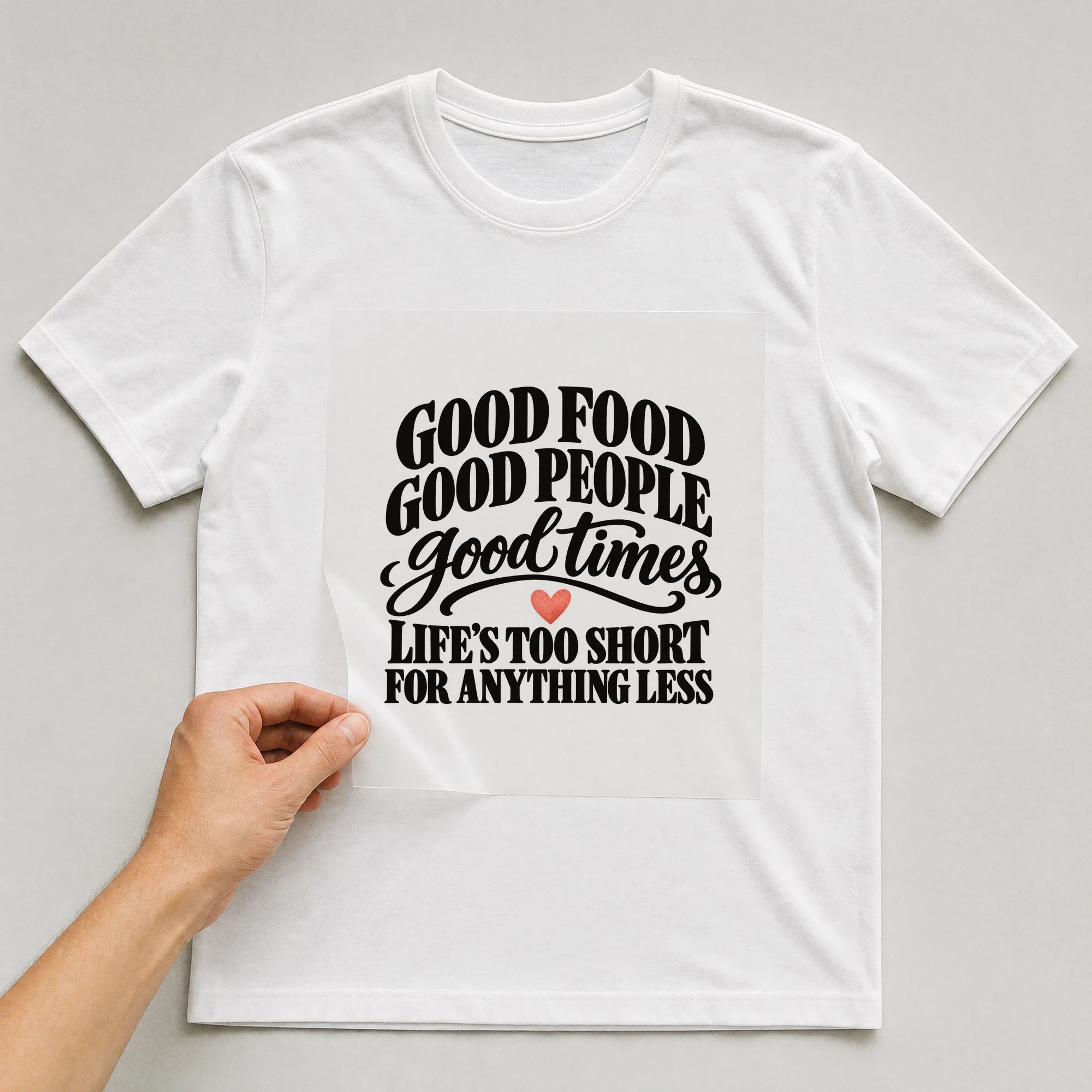 Bügelbild „Good Food Good People Good Times Life's Too Short For Anything Less“ auf weißem T-Shirt, Folie wird aufgelegt