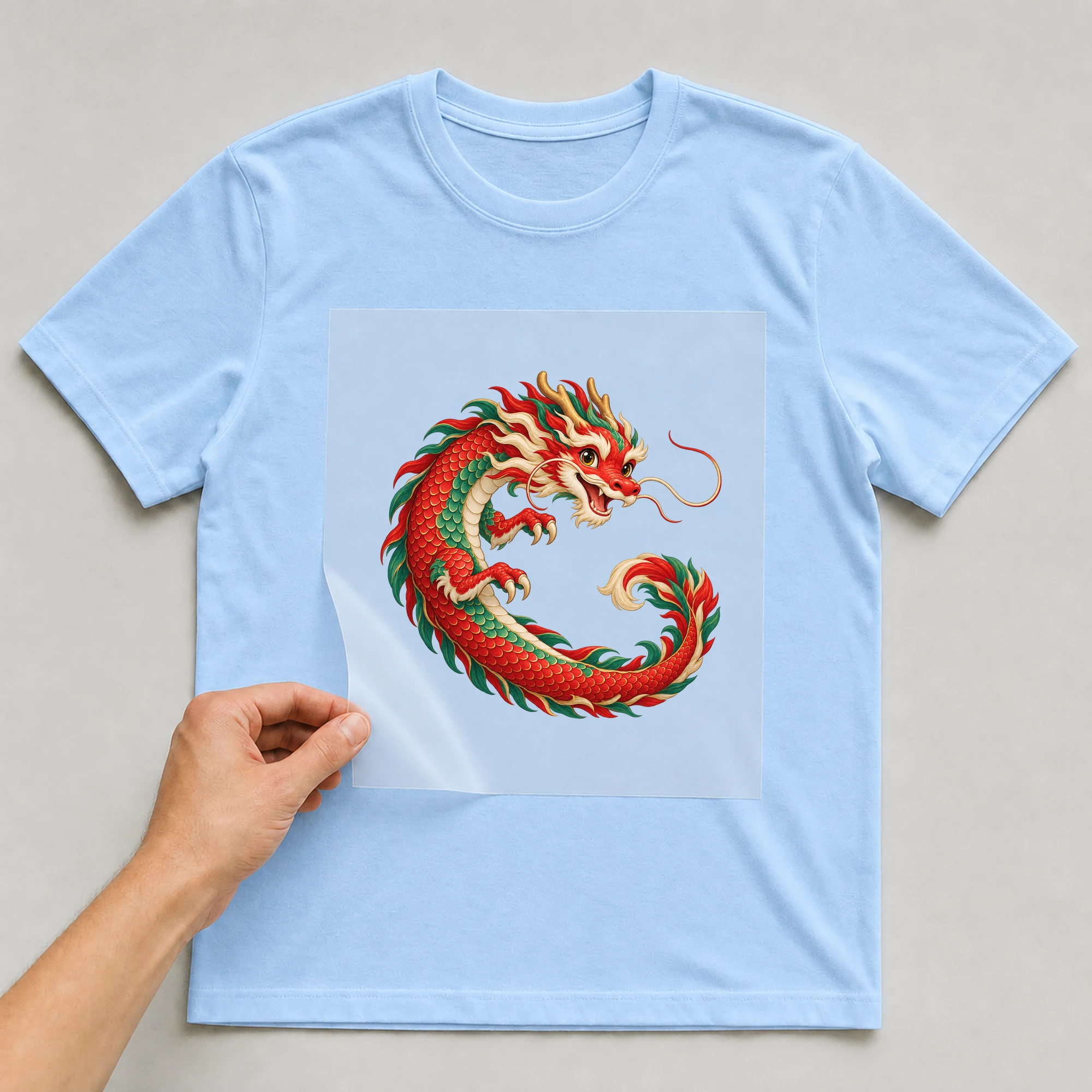 Bügelbild „Chinese Zodiac Year Of The Dragon“ auf babyblauem T-Shirt, Folie wird aufgelegt