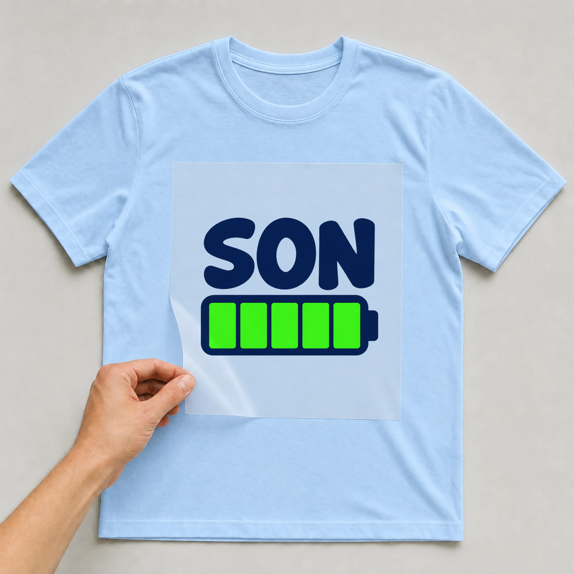 Bügelbild „SON“ auf babyblauem T-Shirt, Folie wird aufgelegt