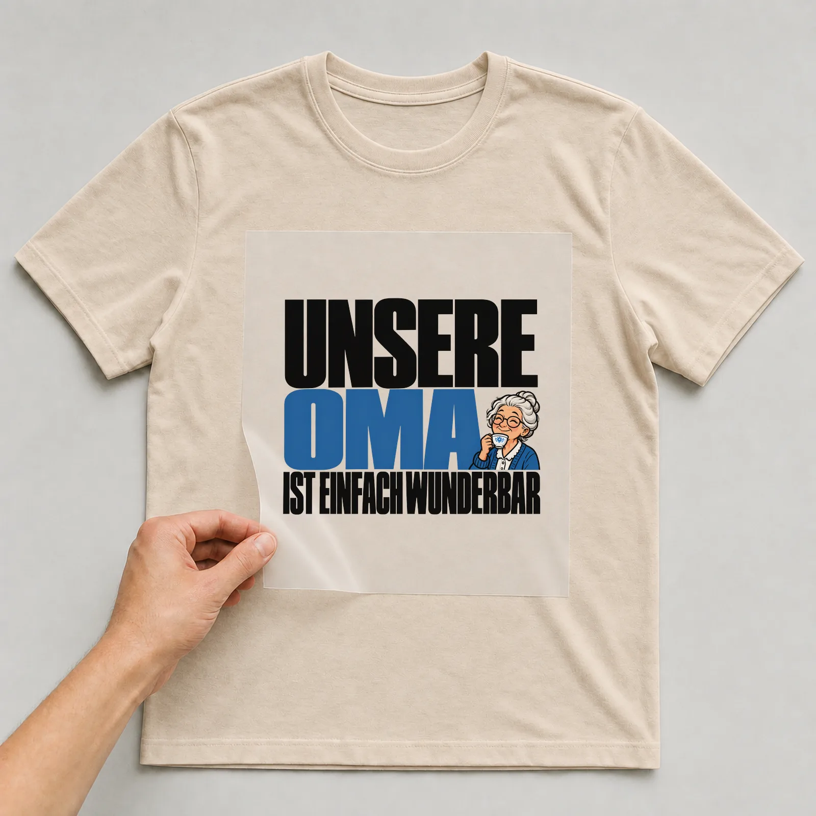 Bügelbild „Unsere Oma ist einfach wunderbar“ auf beigem T-Shirt, Folie wird aufgelegt