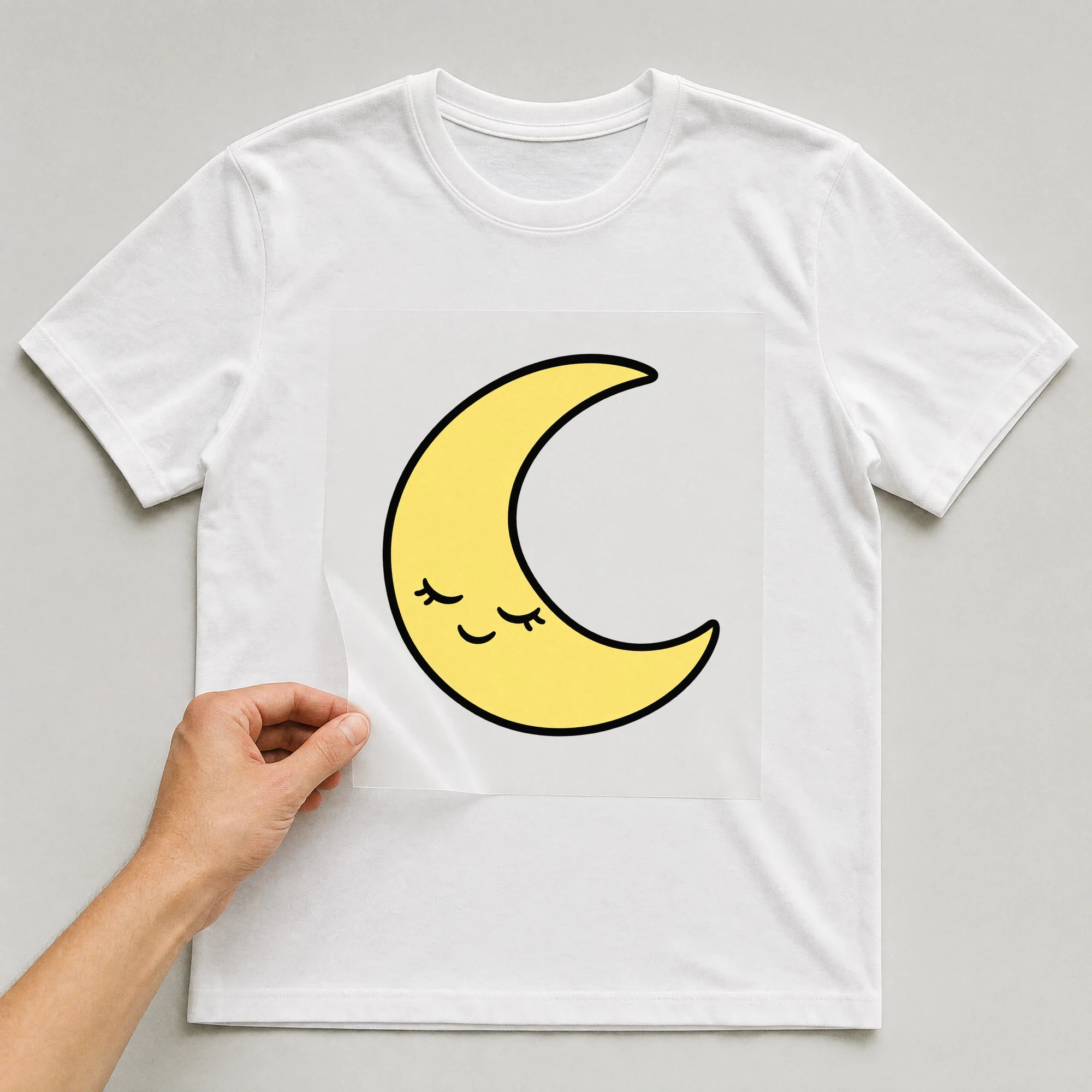 Bügelbild „Lächelnder Mond“ auf weißem T-Shirt, Folie wird aufgelegt