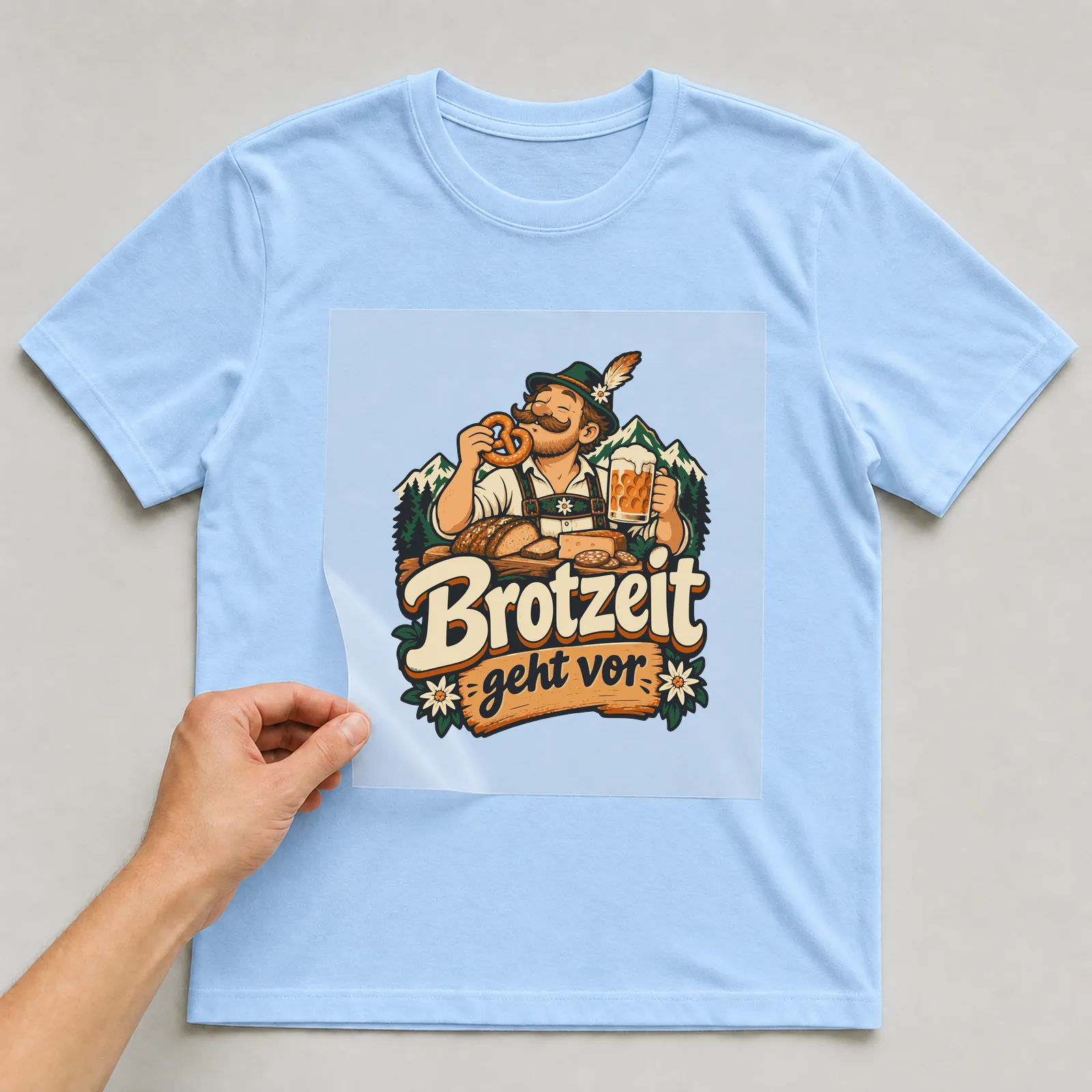 Bügelbild Brotzeit geht vor auf hellblauem T-Shirt, Folie wird aufgelegt