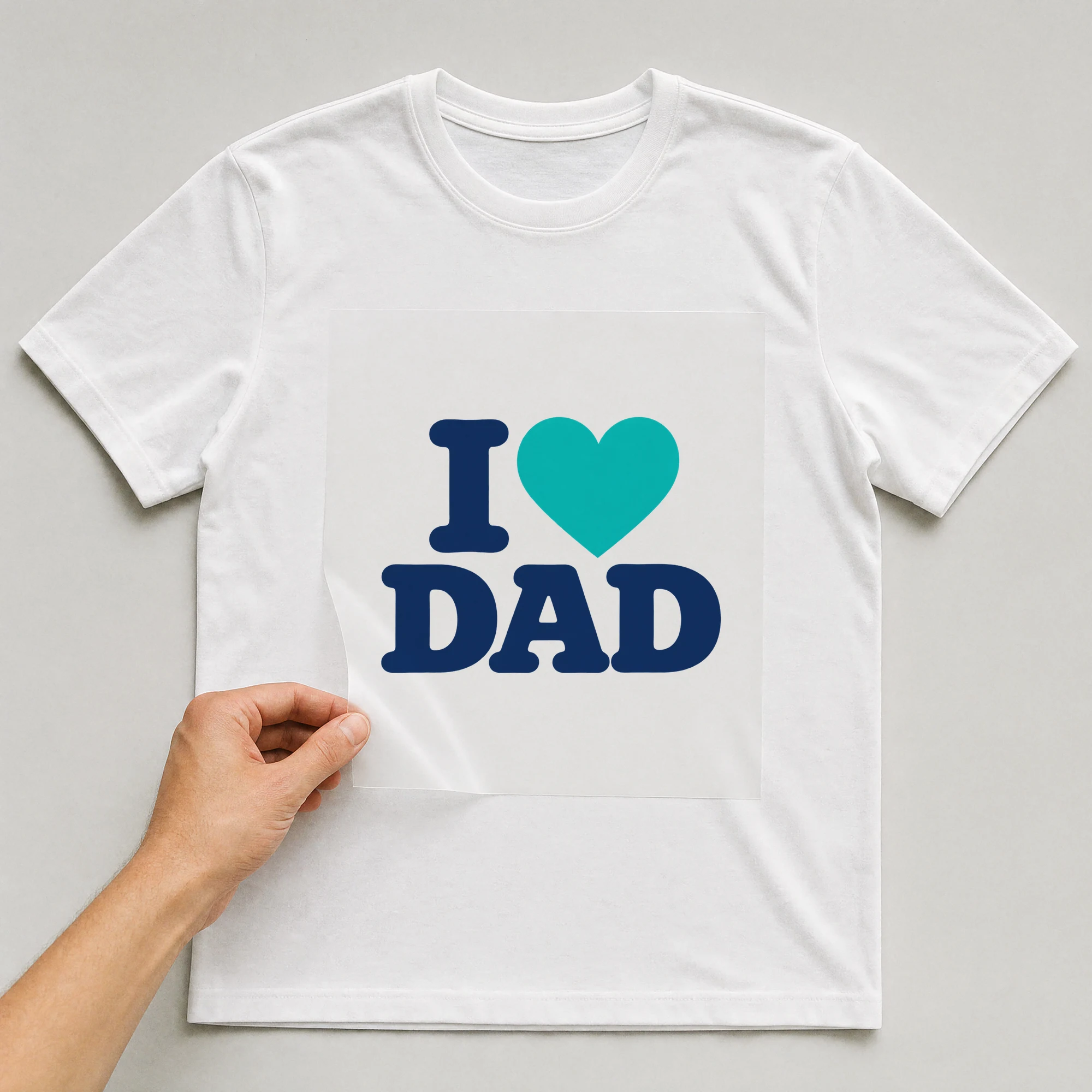 Bügelbild „I Dad“ auf weißem T-Shirt, Folie wird aufgelegt