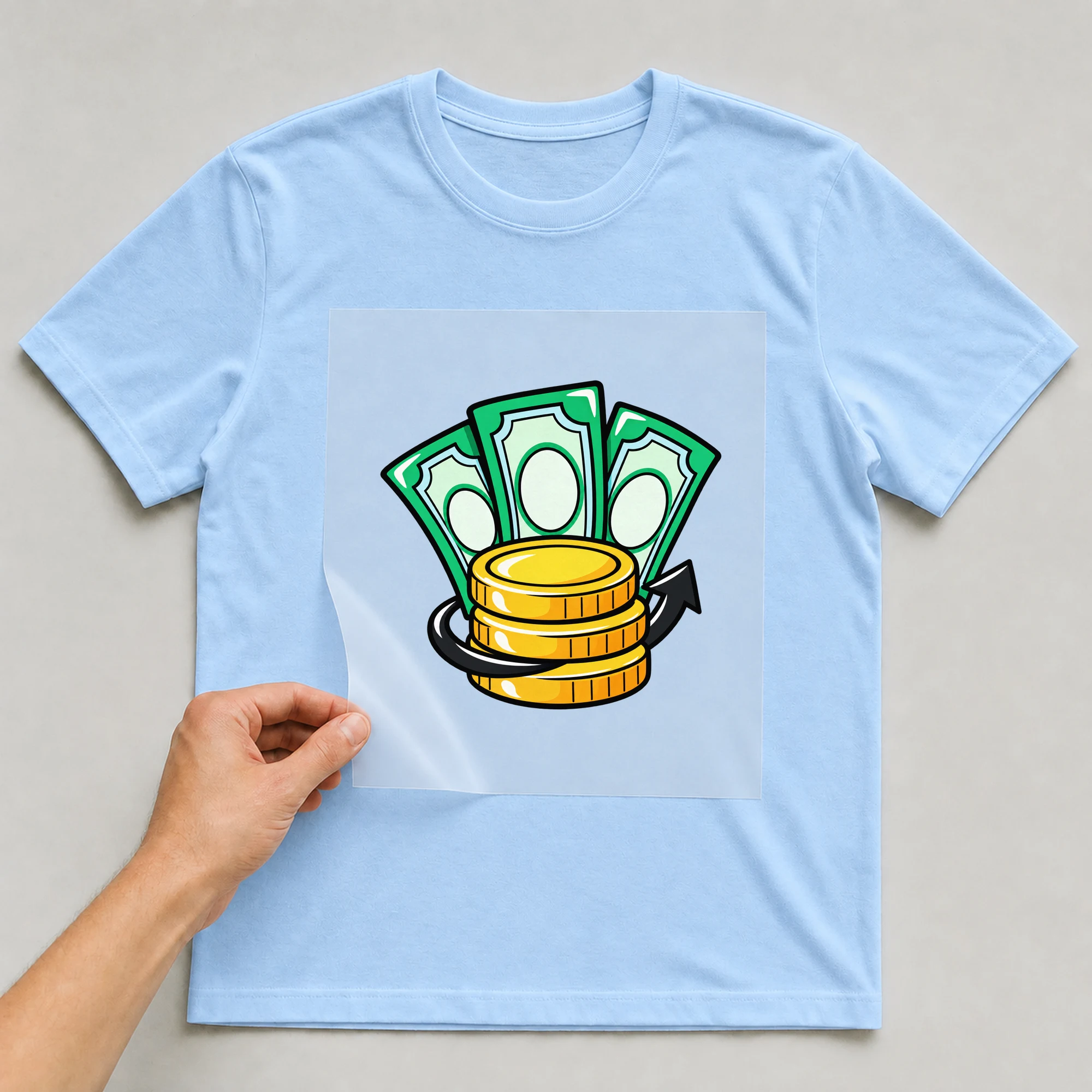 Bügelbild „Pop Art Money“ auf babyblauem T-Shirt, Folie wird aufgelegt