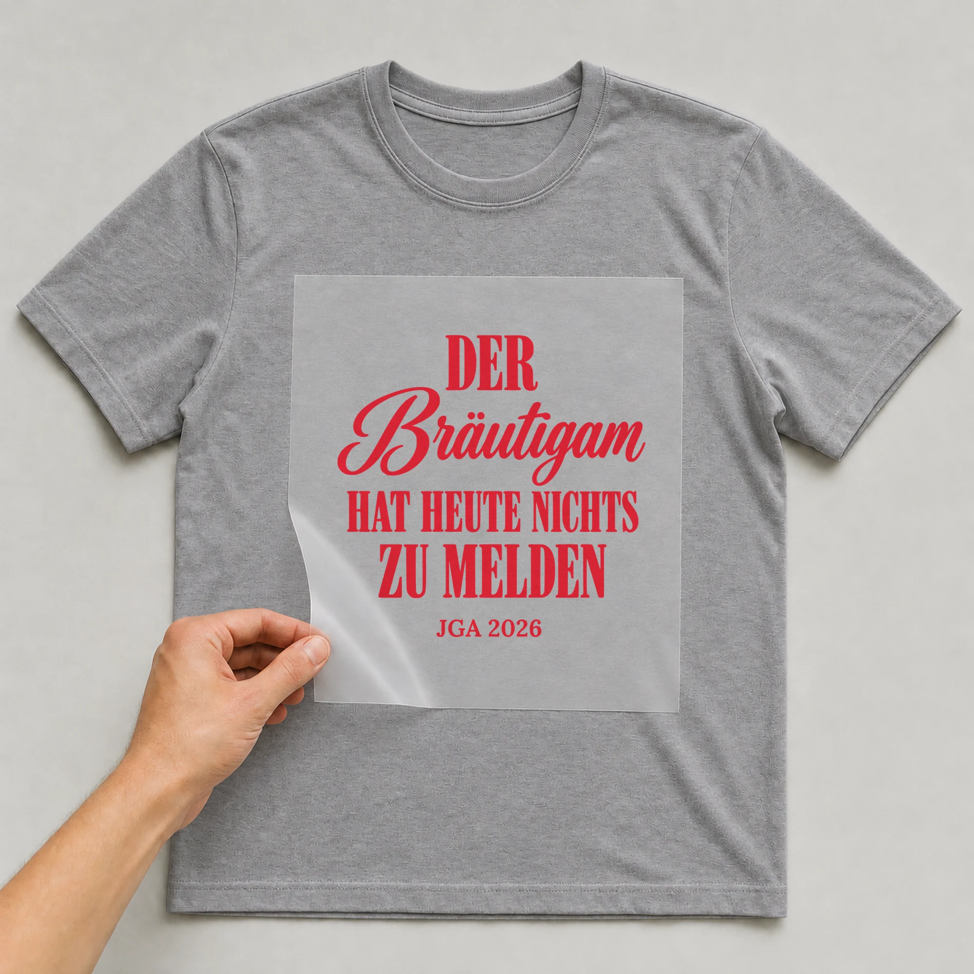 Bügelbild Der Bräutigam hat heute nichts zu melden mit Jahr auf grauem T-Shirt, Folie wird aufgelegt