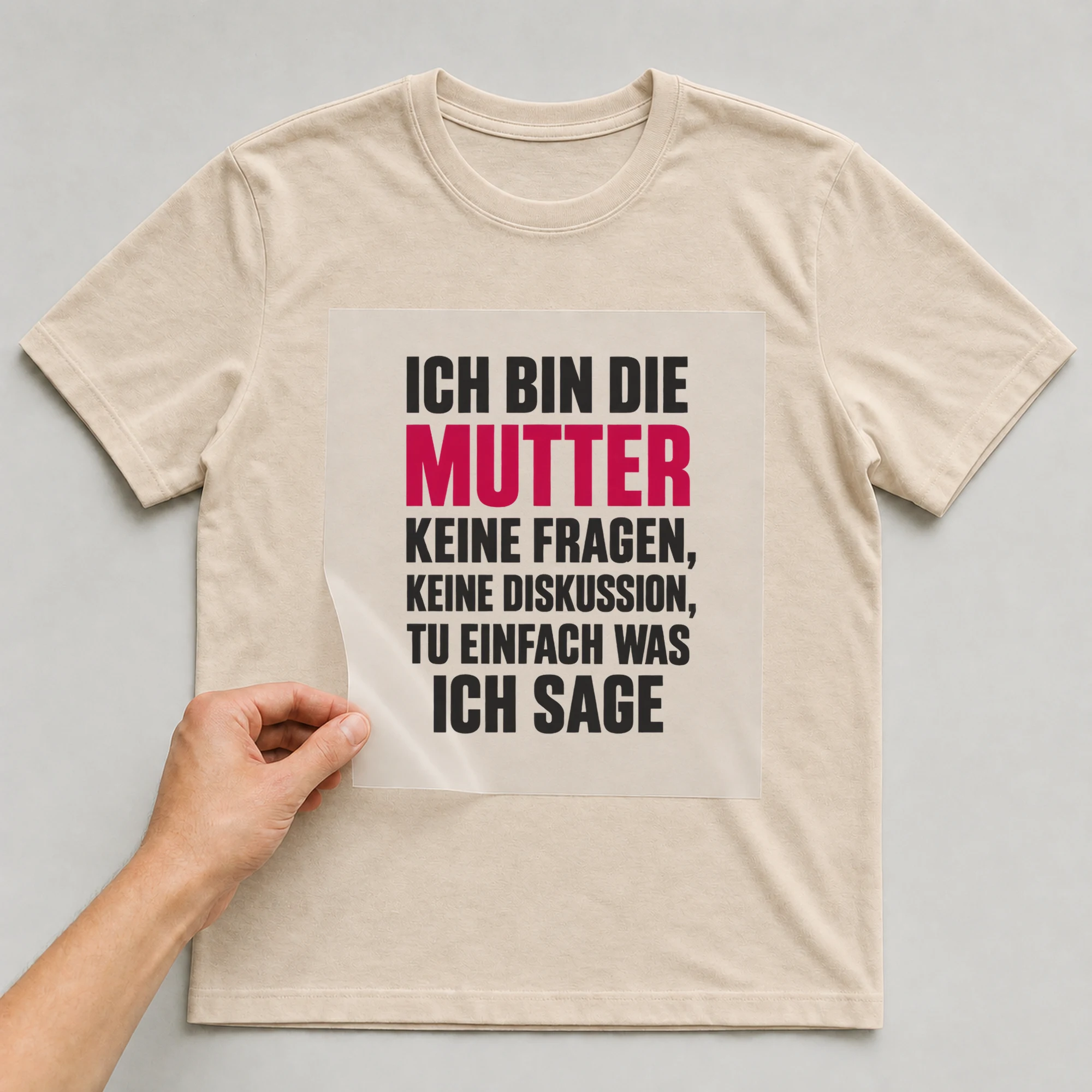 Bügelbild „Ich bin die Mutter keine Fragen, keine Diskussion, tu einfach was ich sage“ auf babyblauem T-Shirt, Folie wird aufgelegt