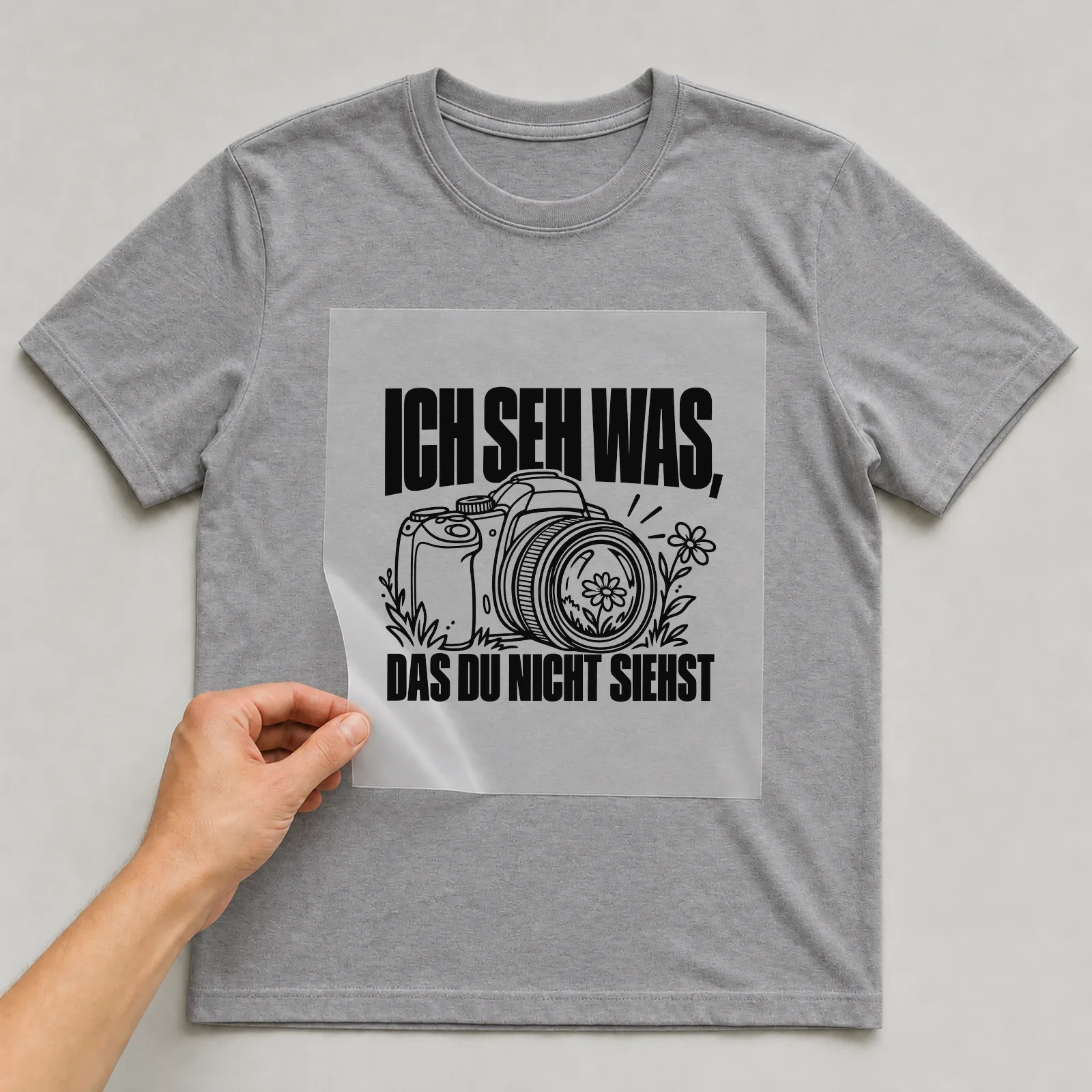 Bügelbild „Ich seh was, das du nicht siehst“ auf grauem T-Shirt, Folie wird aufgelegt